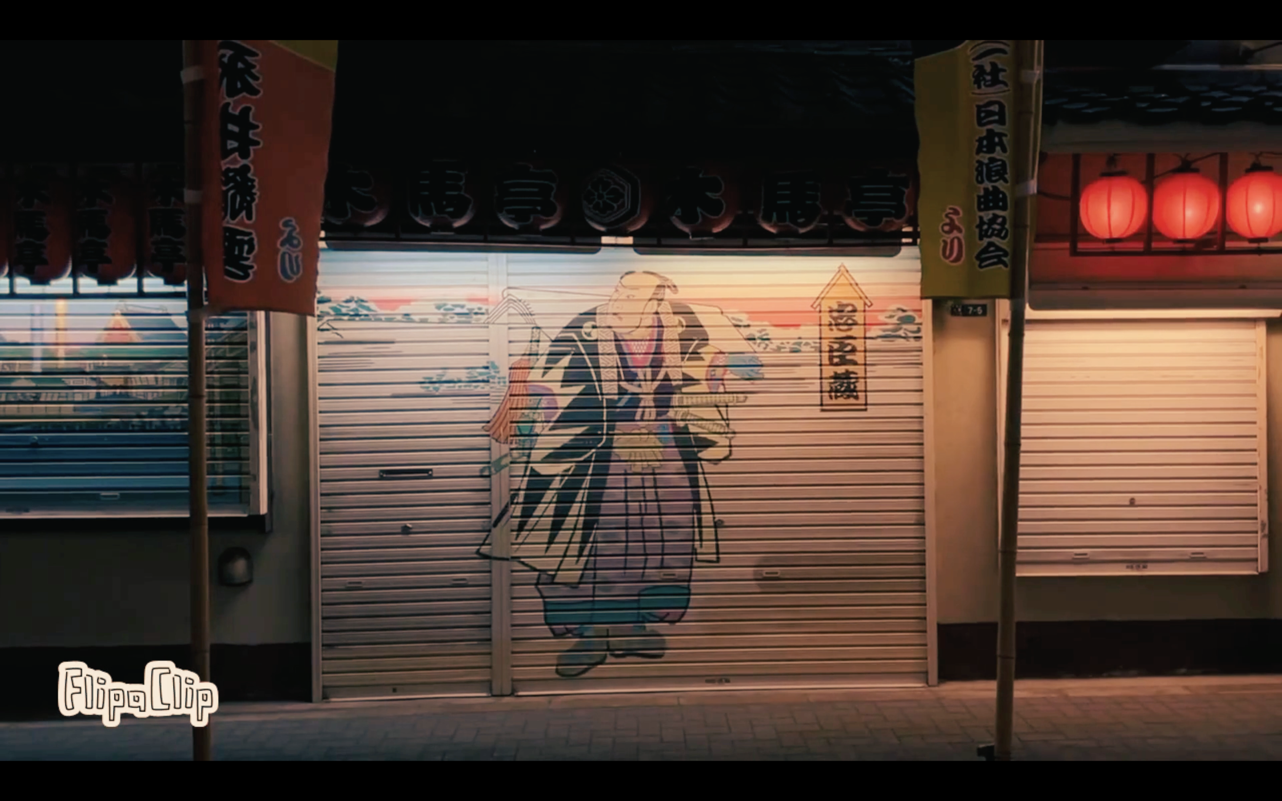 A closed shop with a colorful cartoon painting of a traditional Japanese figure on its metal roll-up door. The shop is decorated with Japanese lanterns and banners, with some text in Japanese.