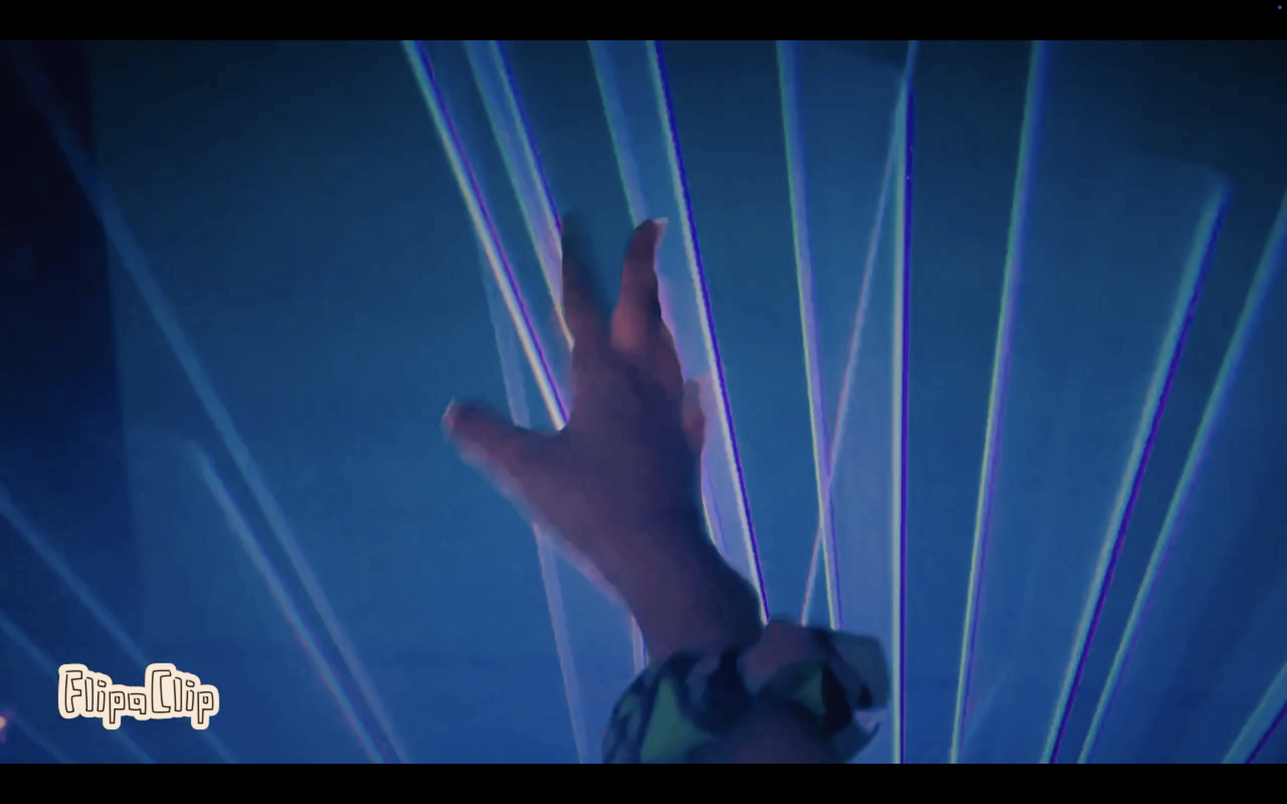 A person's hand reaching towards colorful laser beams against a dark background.
