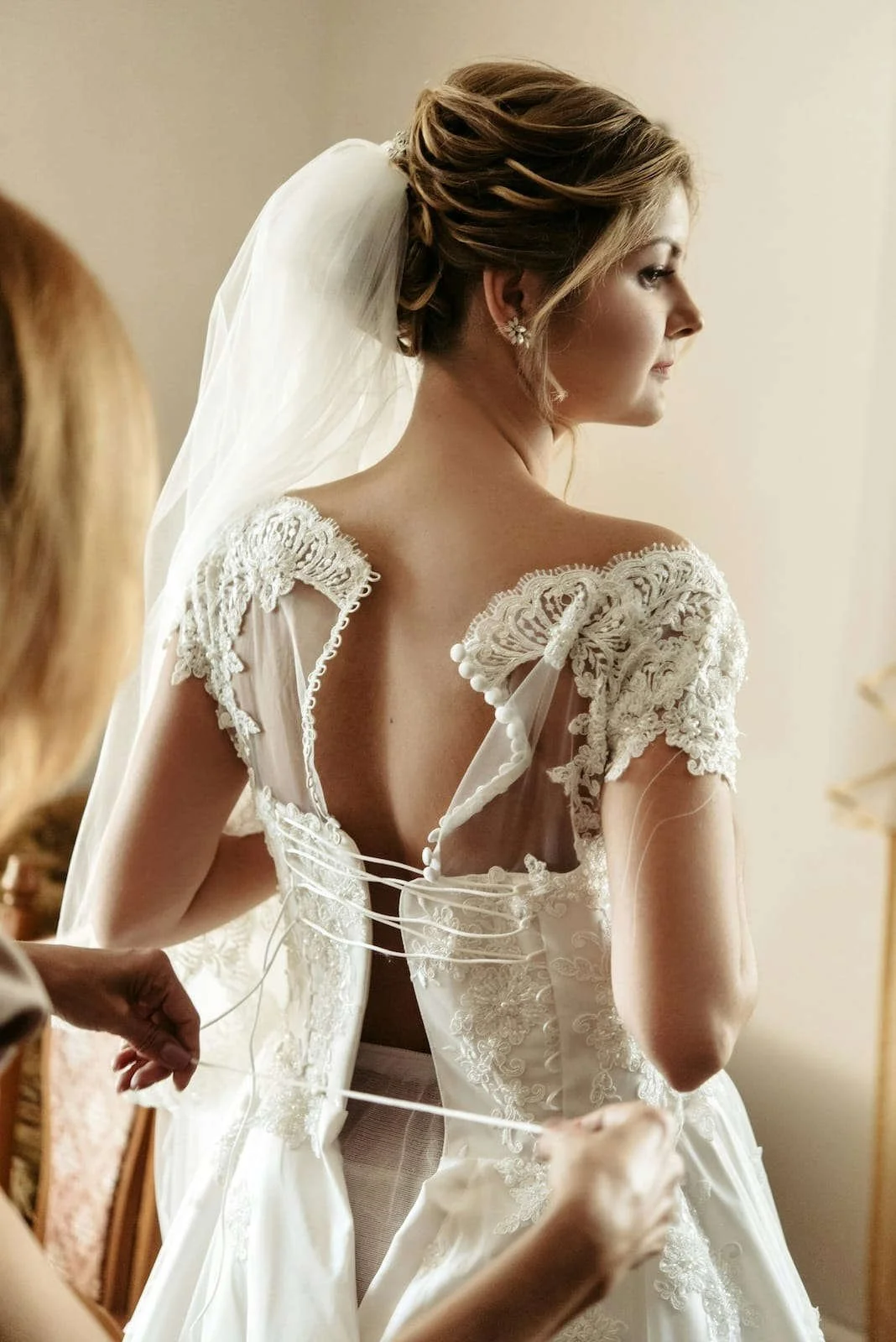 Bride getting ready in a lace wedding dress during morning preparations
