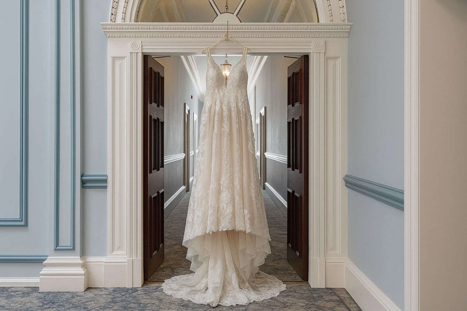 Wedding dress hanging in a grand hallway at Shrigley Hall, Manchester.