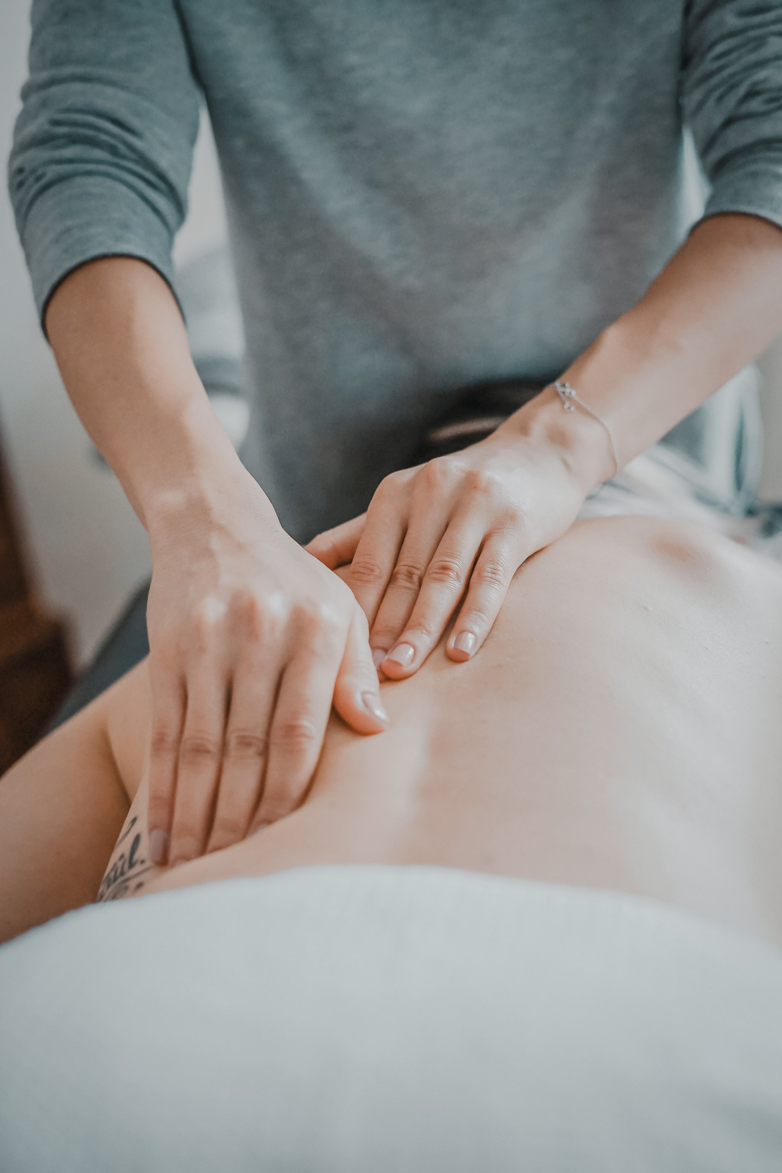 A person receiving a massage on their back from a massage therapist.