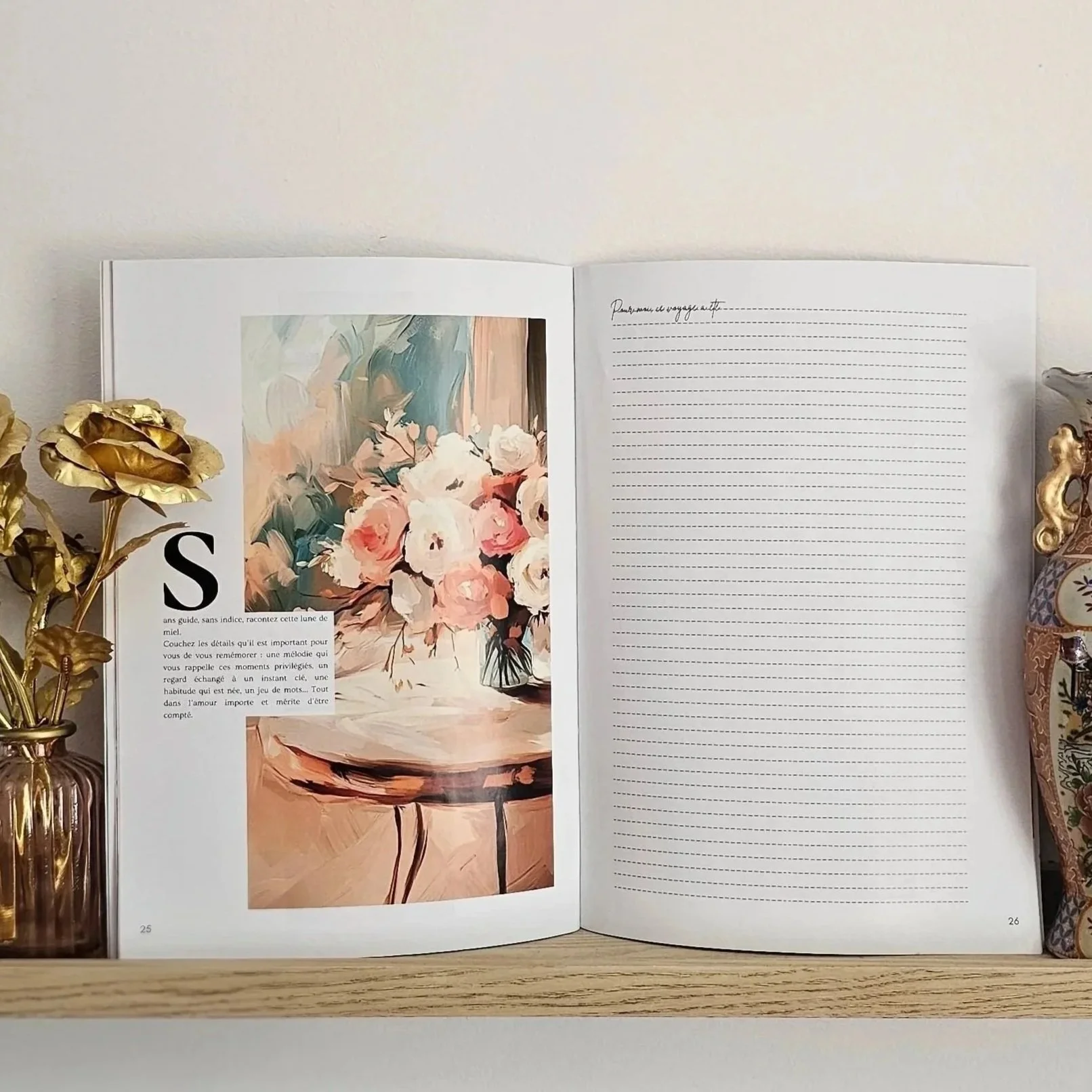 Carnet de mariage Ad Æternam ouvert et posé sur une étagère, entouré de roses dorées, d'un vase fleuri dans une ambiance décorative chaleureuse