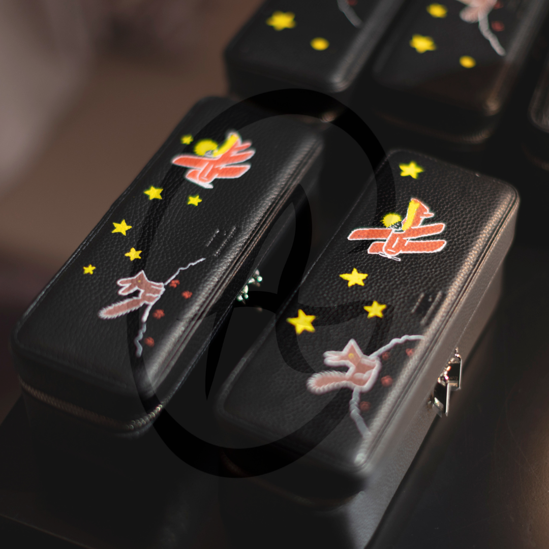 Étuis noirs décorés avec des étoiles, des croissants et des papillons colorés.