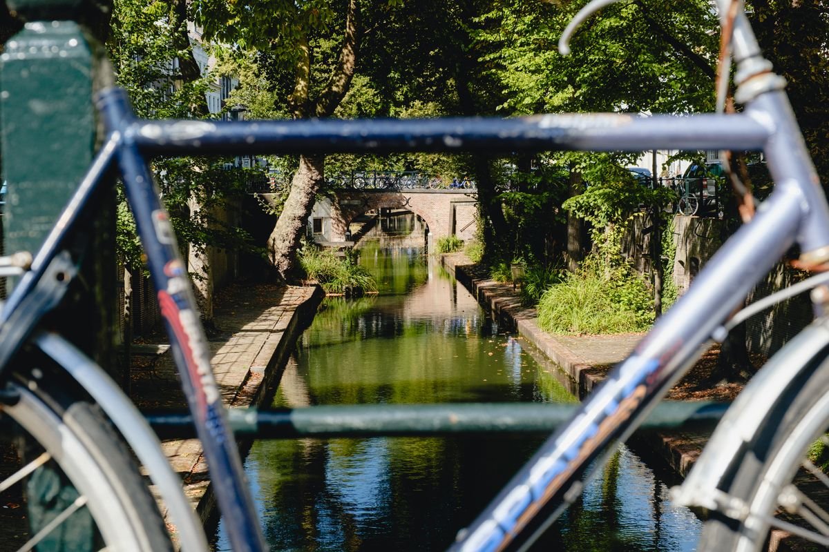 A canal seen through the frame of a parked bicycle