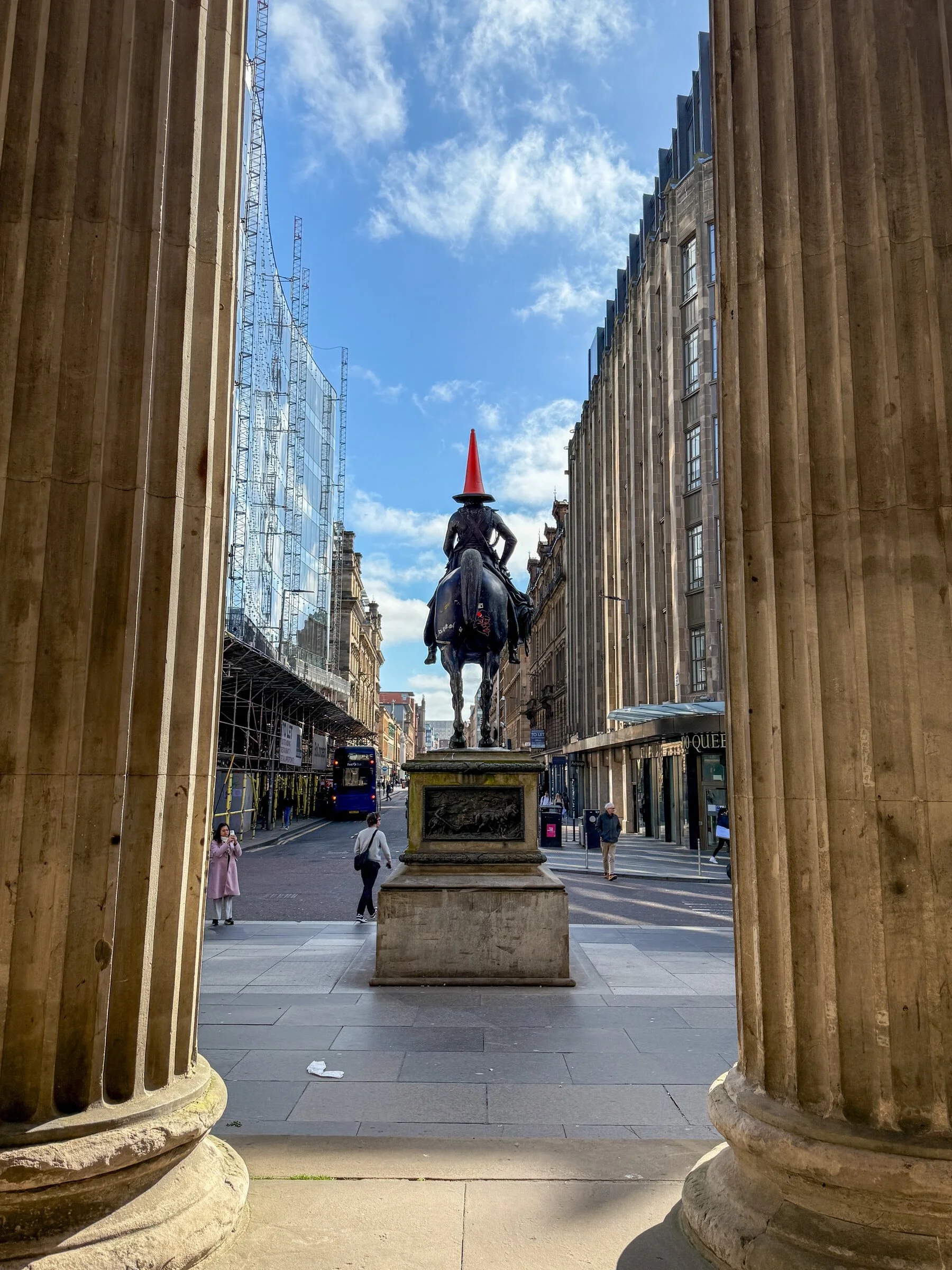 The Duke of Wellington statue, traffic cone on his head, framed by the Gallery of Modern Art's columns