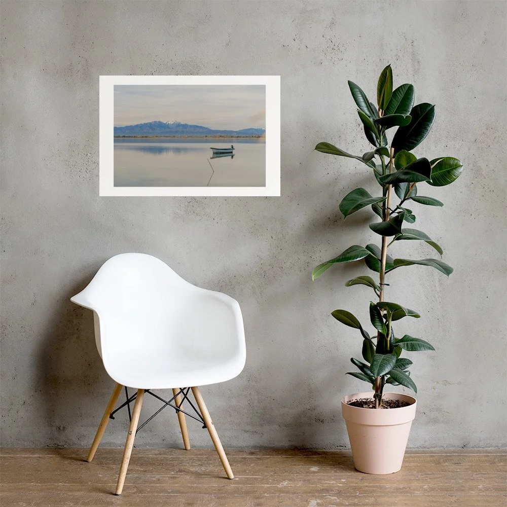 Minimal lake landscape with a solitary boat and distant mountains. A calm fine art photography print.