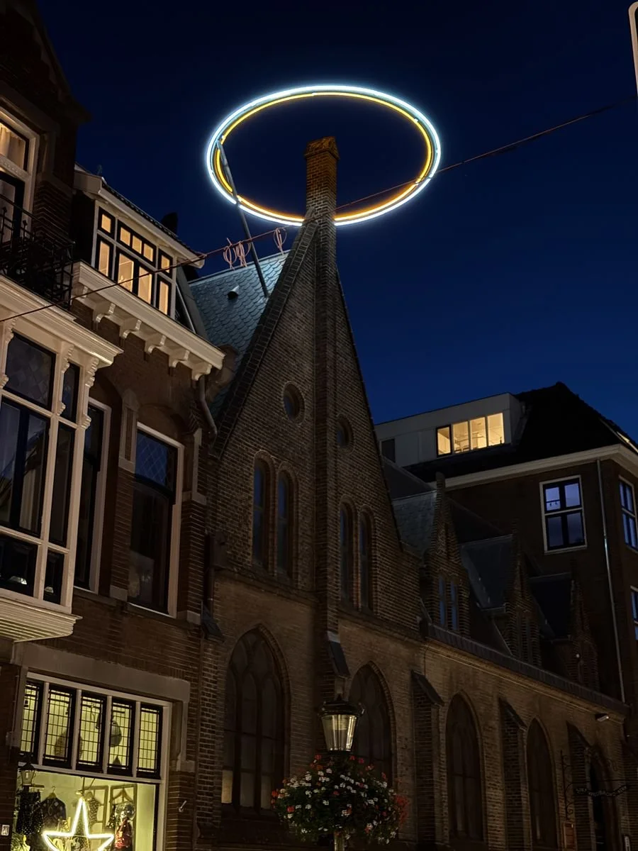 A glowing halo sculpture crowns a chimney at dusk