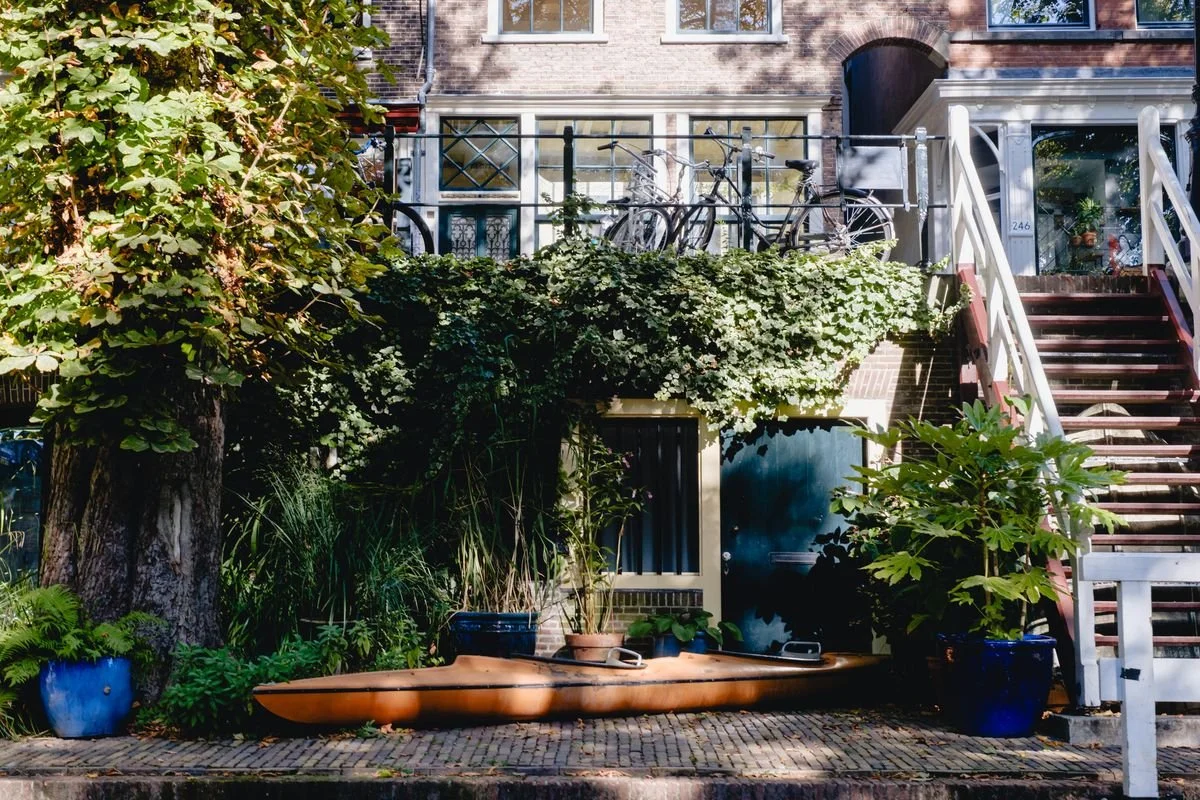 A kayak rests against an ivy-covered canal house
