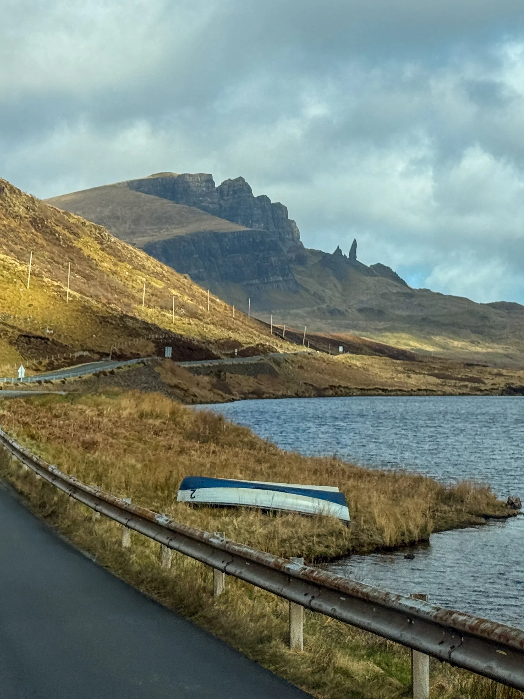 The jagged Old Man of Storr rock formation rises above a loch on the Isle of Skye