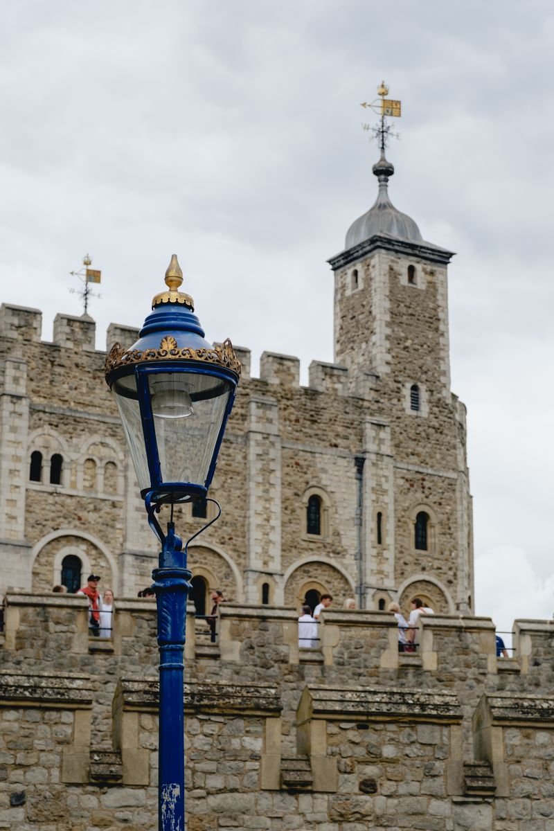 A blue Victorian lamppost stands before the Tower of London's White Tower