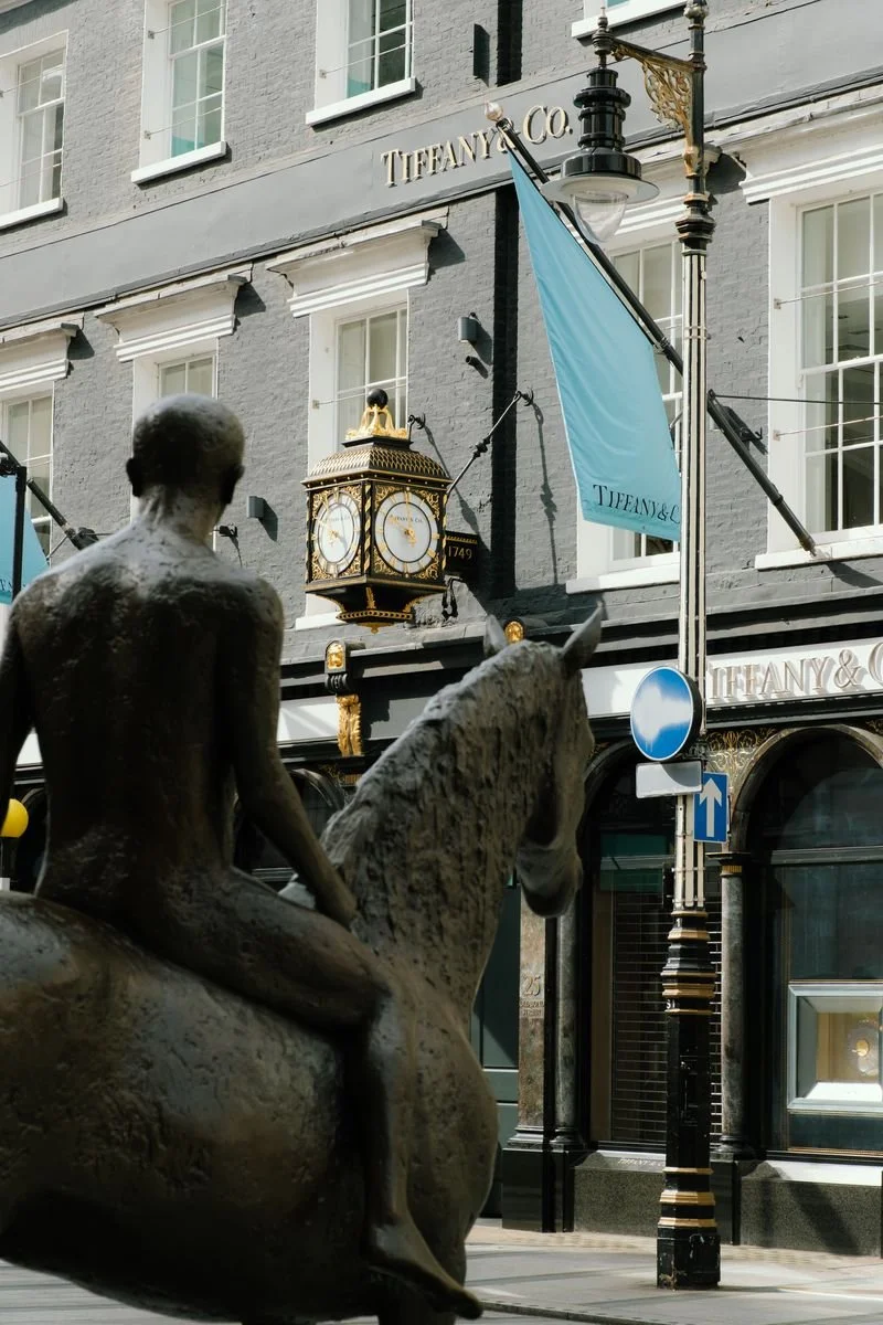 A bronze equestrian statue faces Tiffany and Co.'s gilded clock