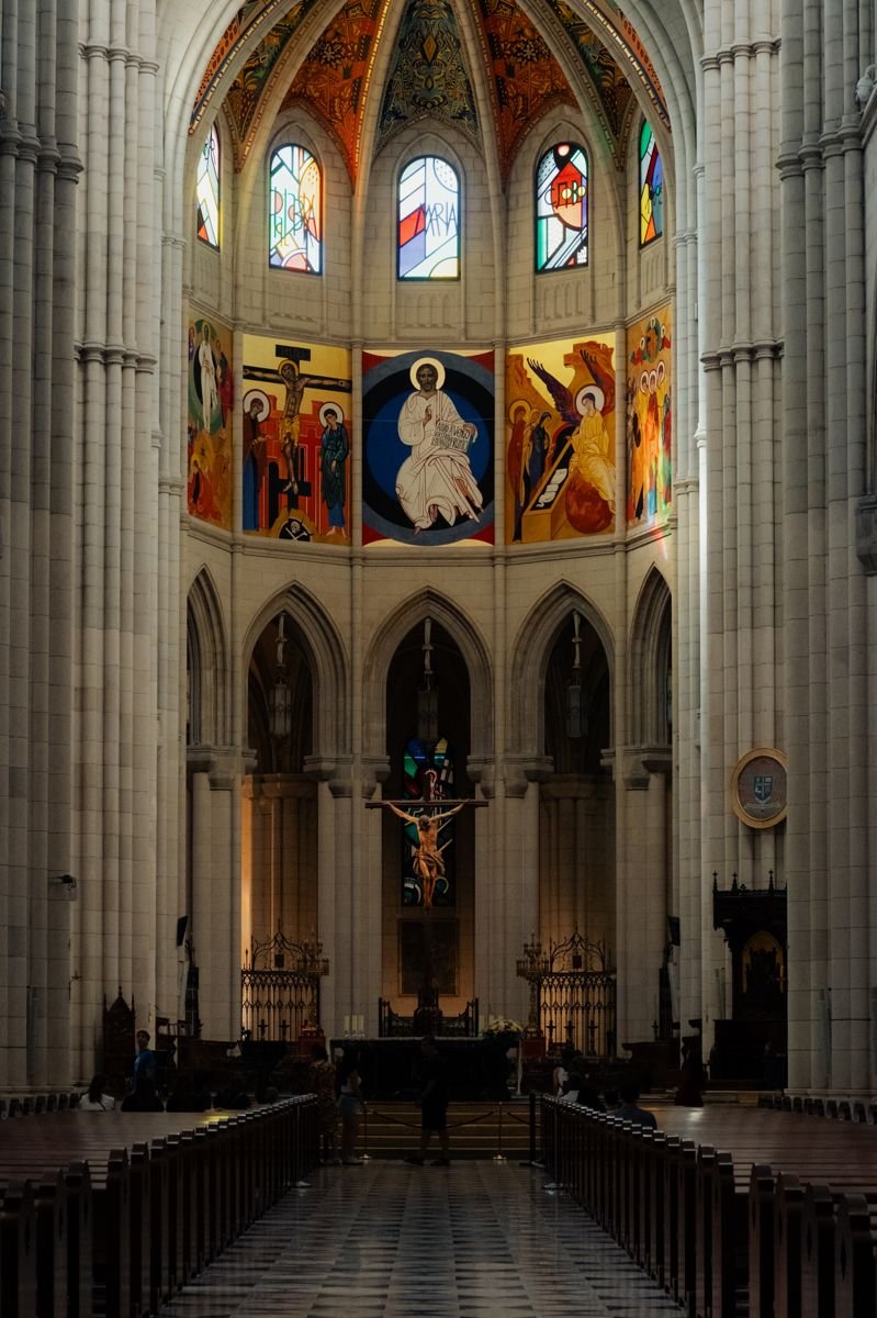 The apse of the Almudena Cathedral, colorful modern frescoes and stained glass above the altar