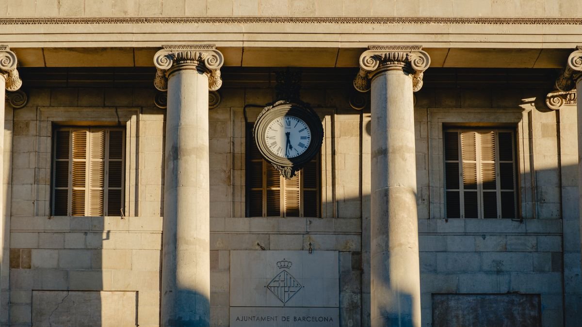A clock hangs between Ionic columns on the Ajuntament de Barcelona's facade