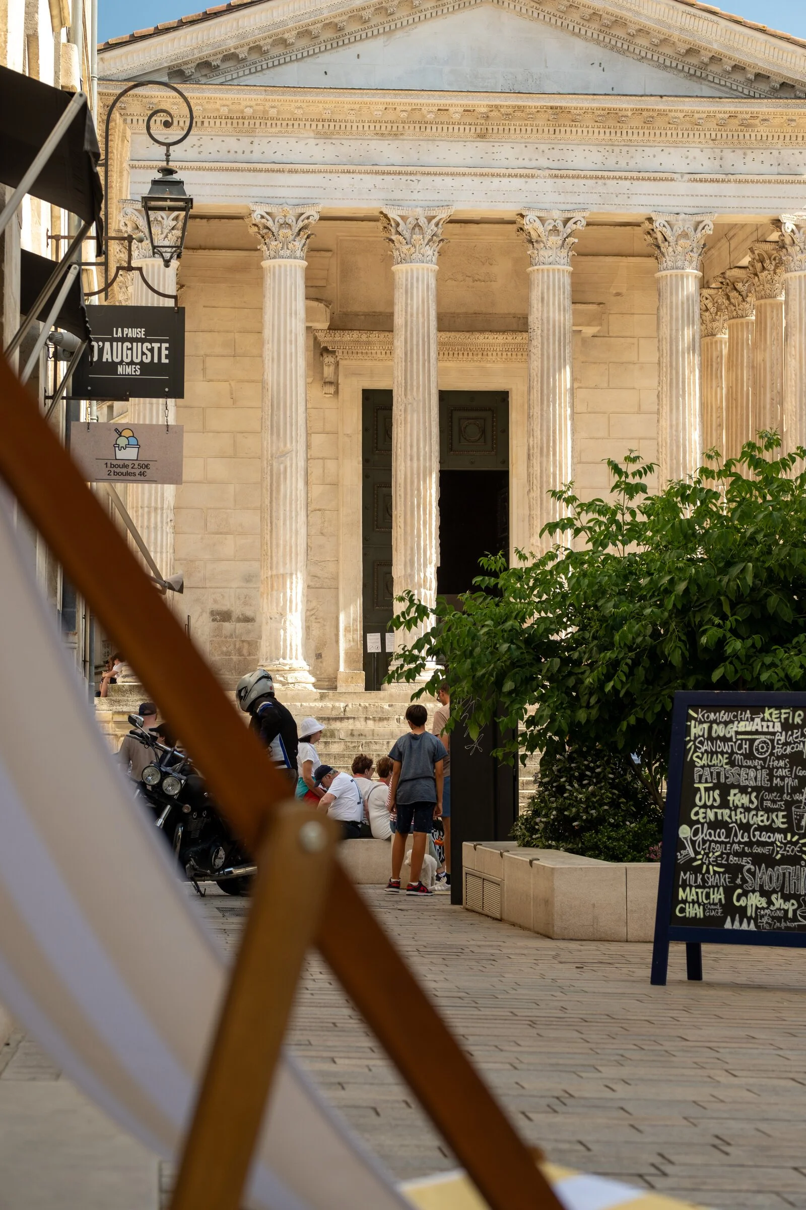 Corinthian columns of the ancient Roman temple Maison Carrée rise above a square in Nîmes