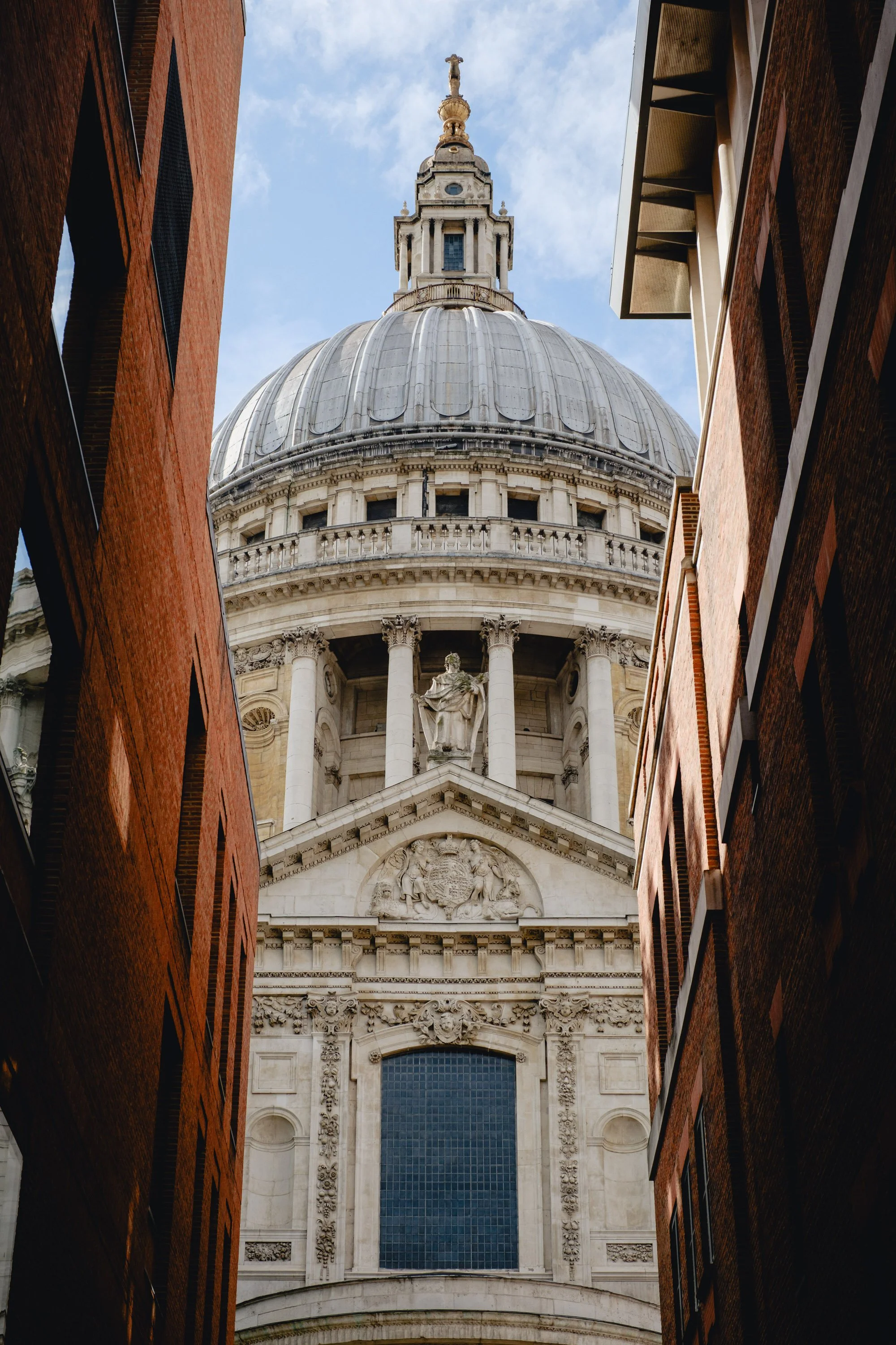 View of St. Paul's Cathedral in London seen between two brick buildings.