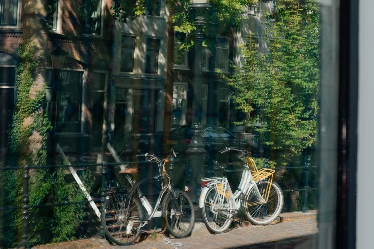 Bicycles glimpsed in the reflection of a canal-house window