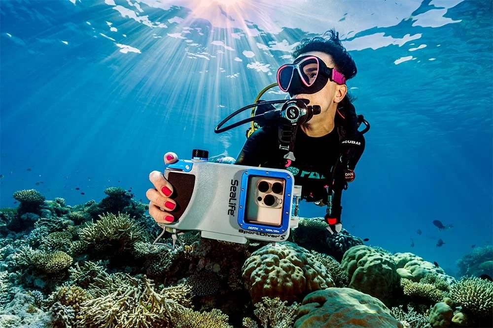 Diver descending underwater while carrying a SeaLife SportDiver S housing