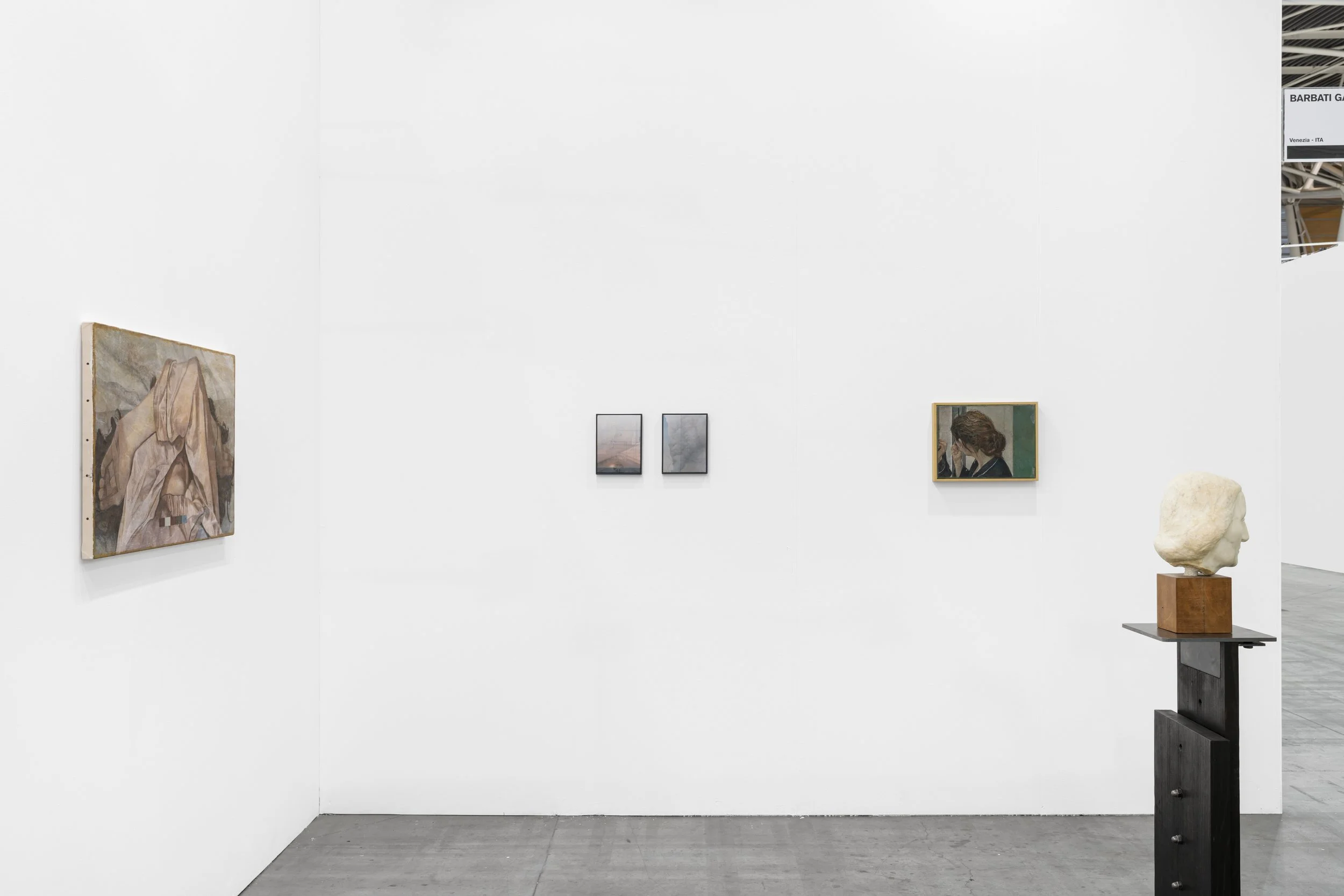 An image of the booth at art fair Artissima featuring paintings and sculptures. 