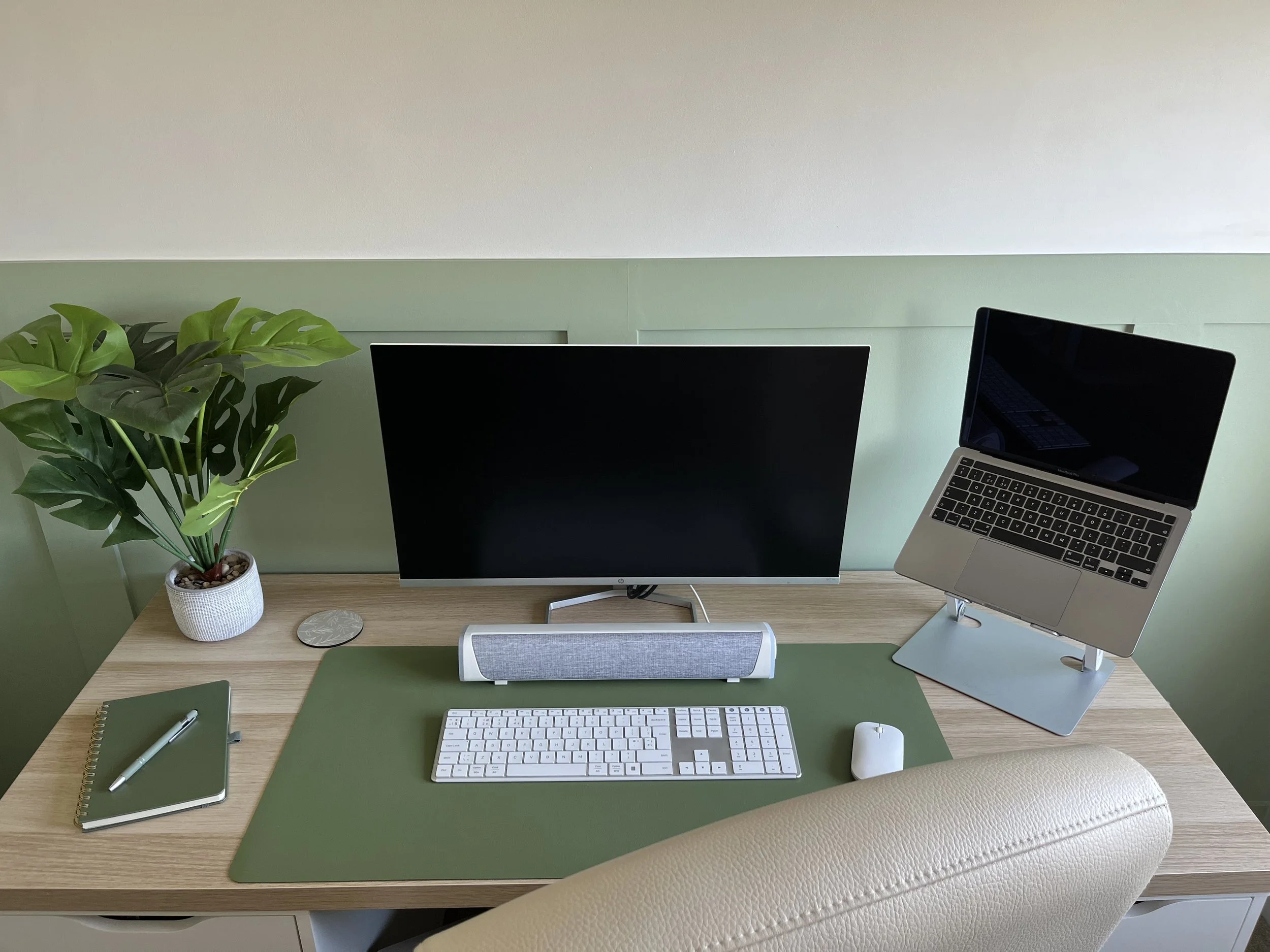 Image of office desk layout with green wall panelling and decor.