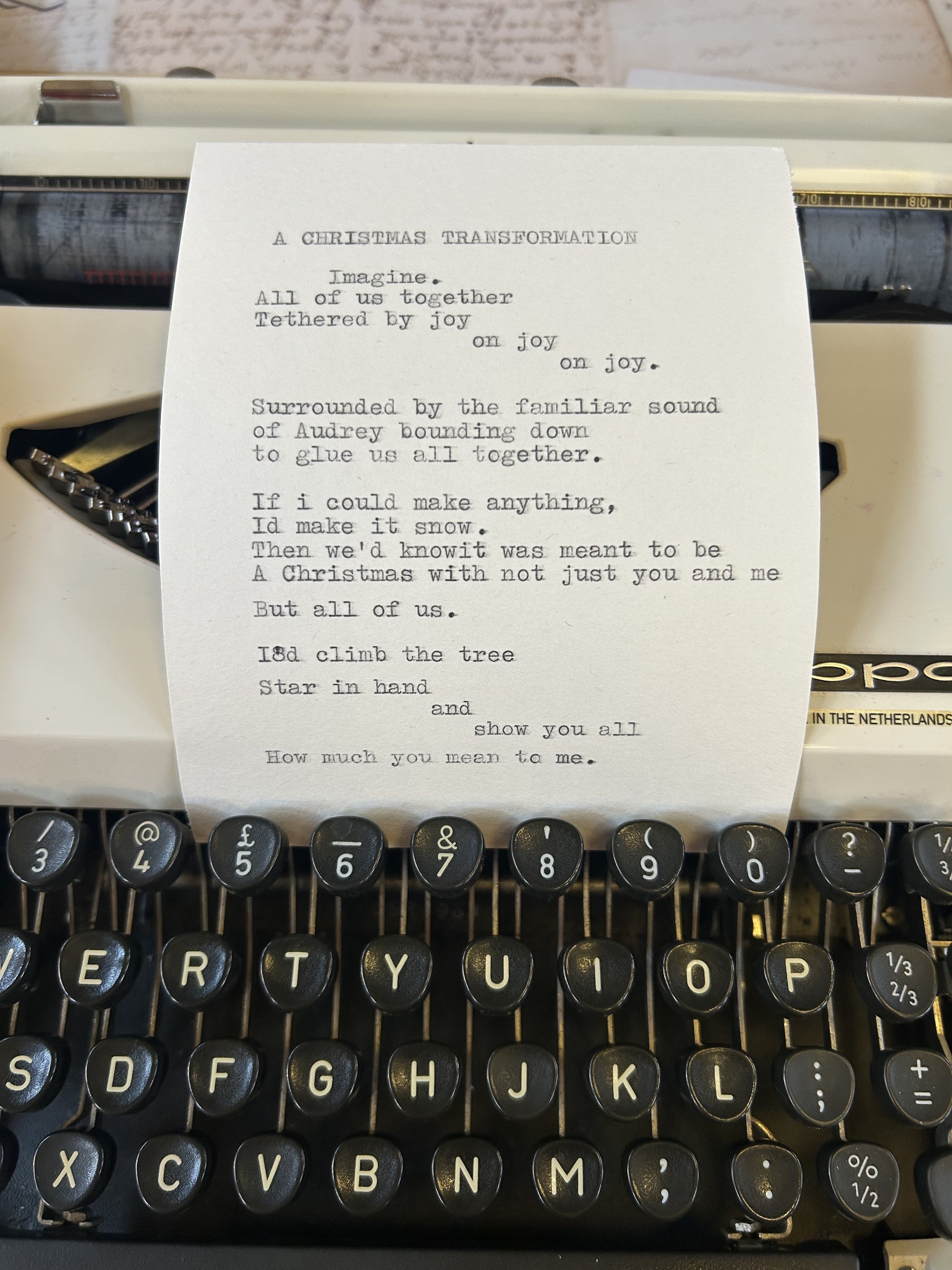 A typed poem titled 'A Christmas Transformation' on a sheet of paper placed on an vintage typewriter.