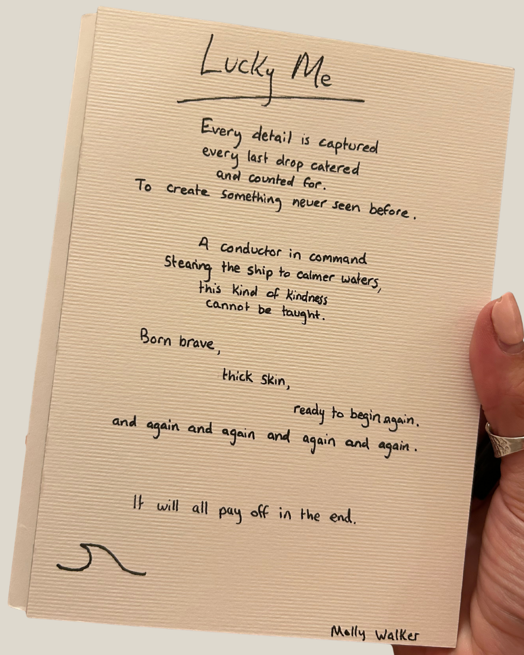 A handwritten poem titled 'Lucky Me' on beige textured paper, held by a person wearing a ring on their finger.