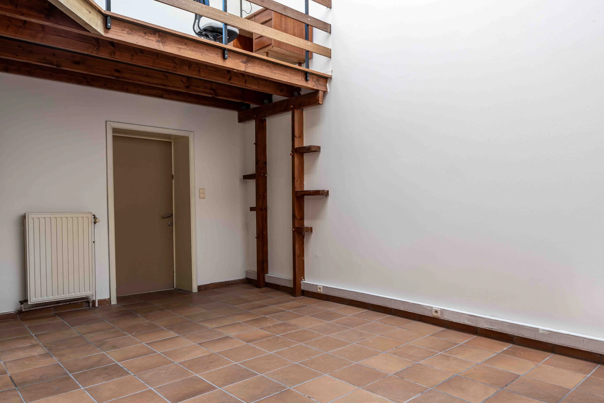 Espace studio photo vide à Bruxelles avec mur blanc et grande surface