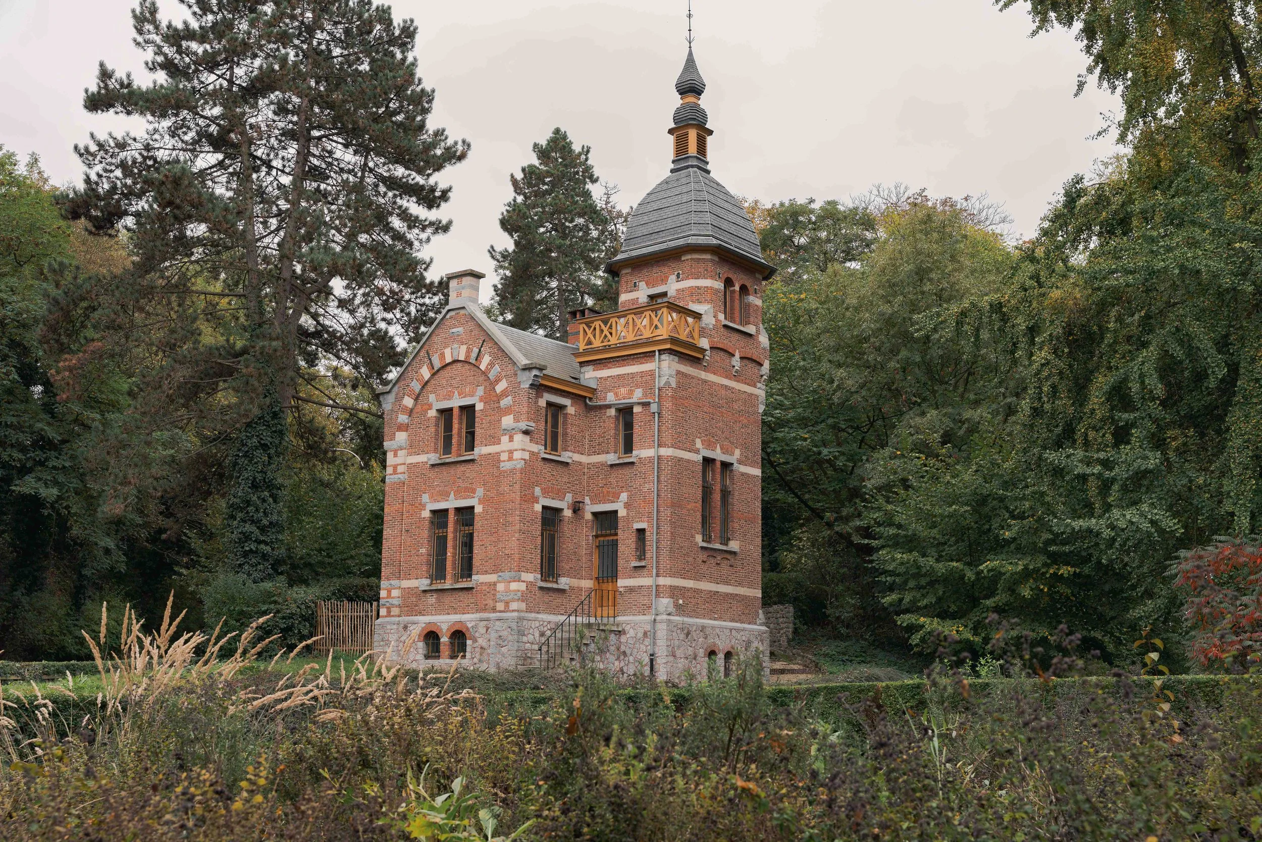 Bâtiment patrimonial en brique dans un environnement végétal. La photographie montre l’implantation, l’échelle et le rapport au paysage.