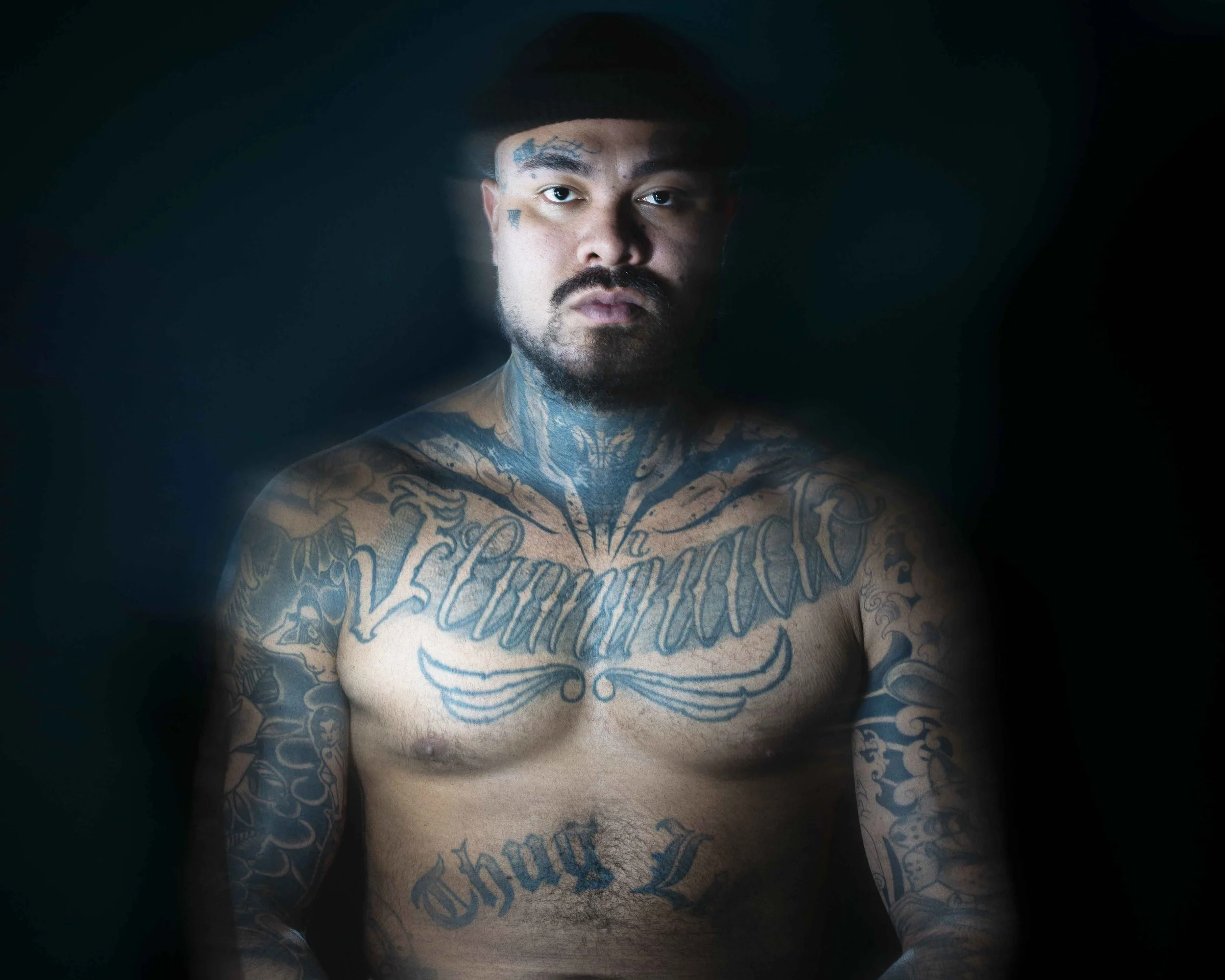 Portrait studio à Bruxelles d’un homme tatoué, lumière modelée et fond sombre. Photographe portrait pour indépendant, artiste et dirigeant recherchant une image forte, authentique et impactante pour site internet, presse ou communication.