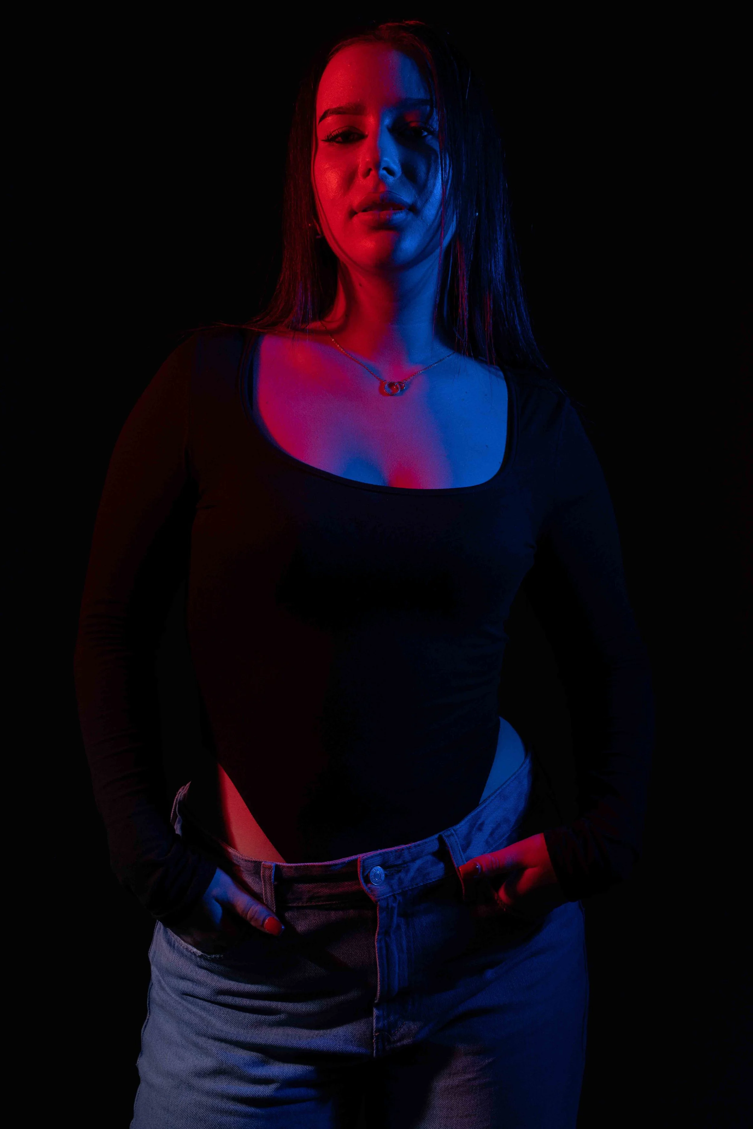 Portrait féminin en lumière bleue et rouge avec arrière-plan discret. Atmosphère cinématographique et rendu dramatique.