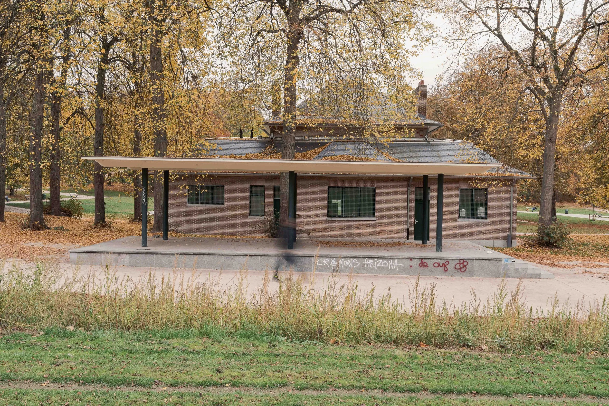 Façade moderniste en brique dans un environnement végétal. L’image met en avant l’intégration au site et la cohérence des lignes.