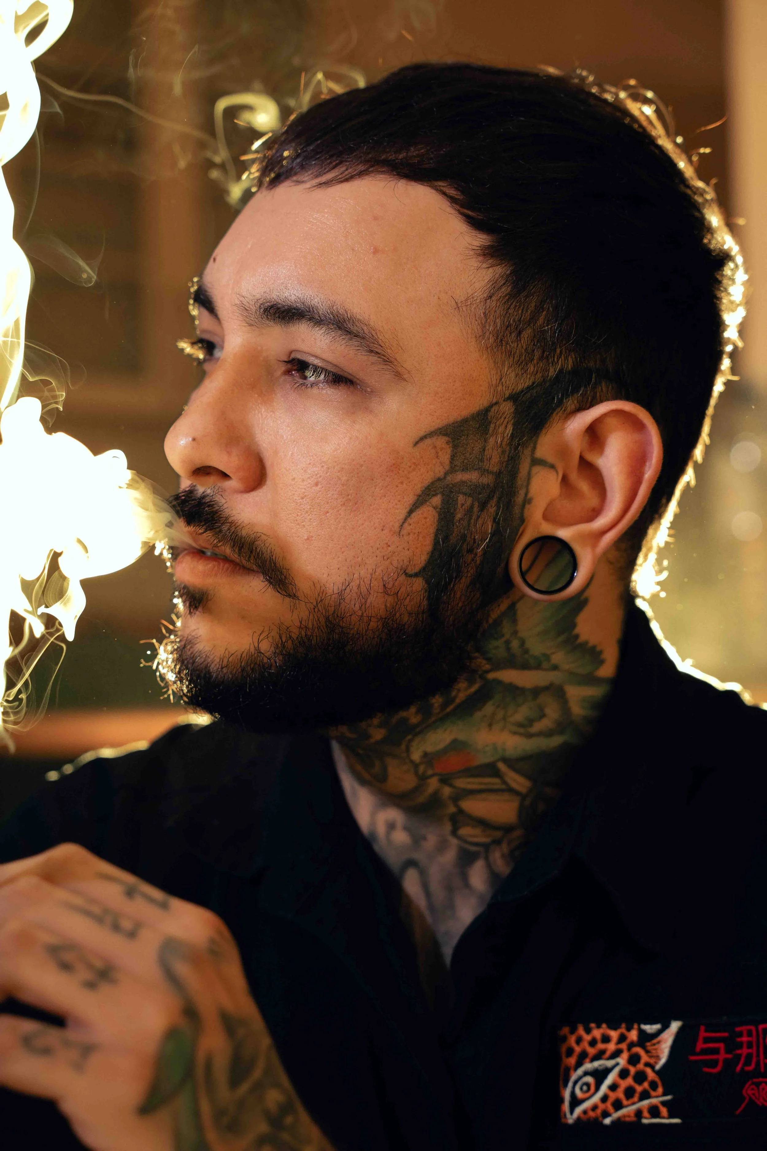 Portrait couleur d’un homme en lumière artificielle. Cadrage serré et accent mis sur le regard.