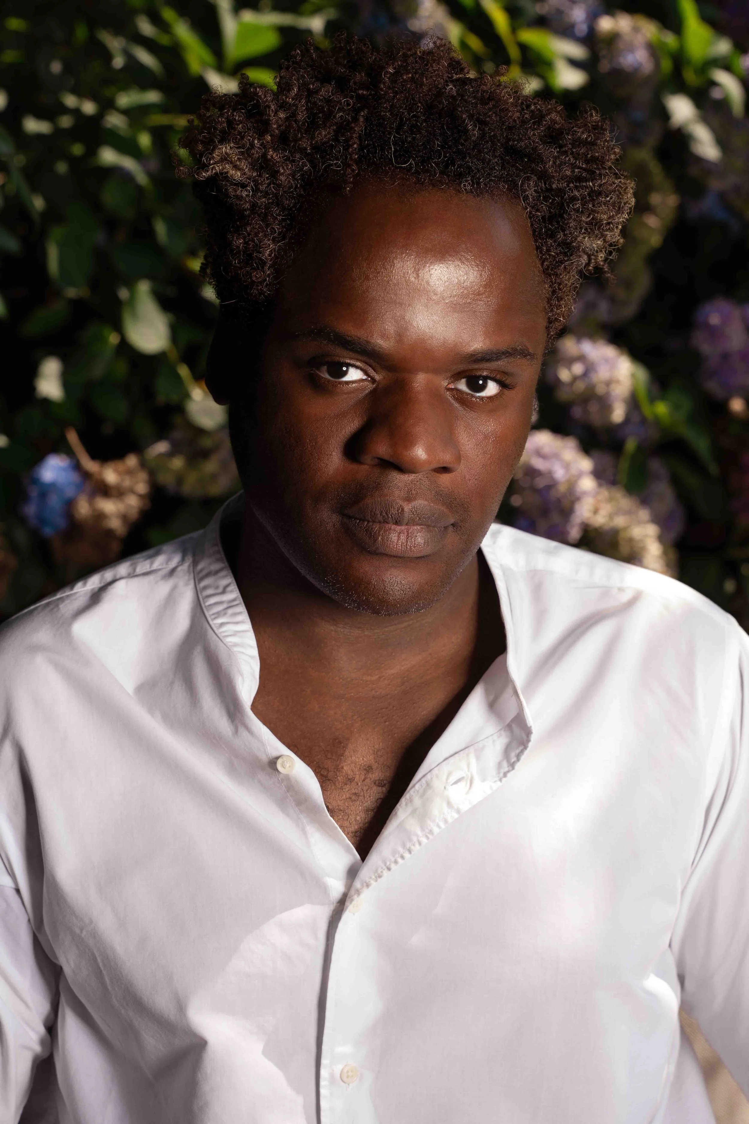 Portrait en extérieur avec fond végétal flouté. Lumière naturelle équilibrée et rendu authentique.