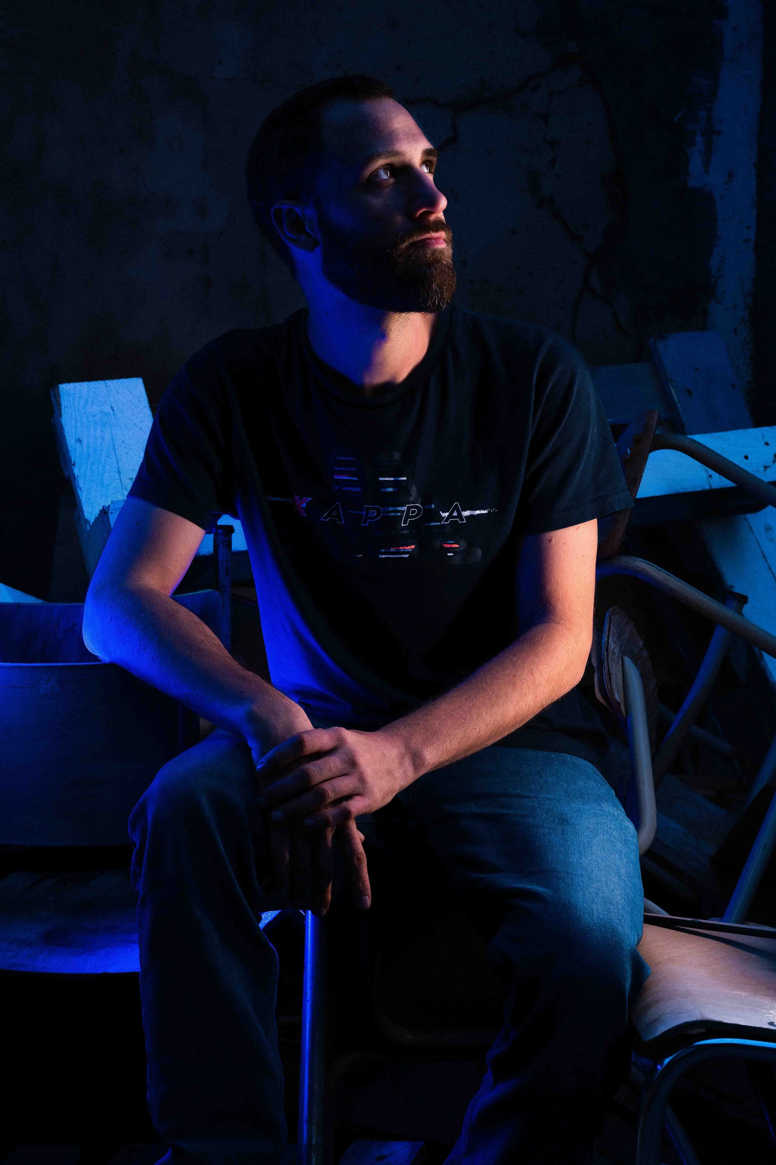 Portrait extérieur avec éclairage coloré bleu. Contraste marqué et ambiance contemporaine.