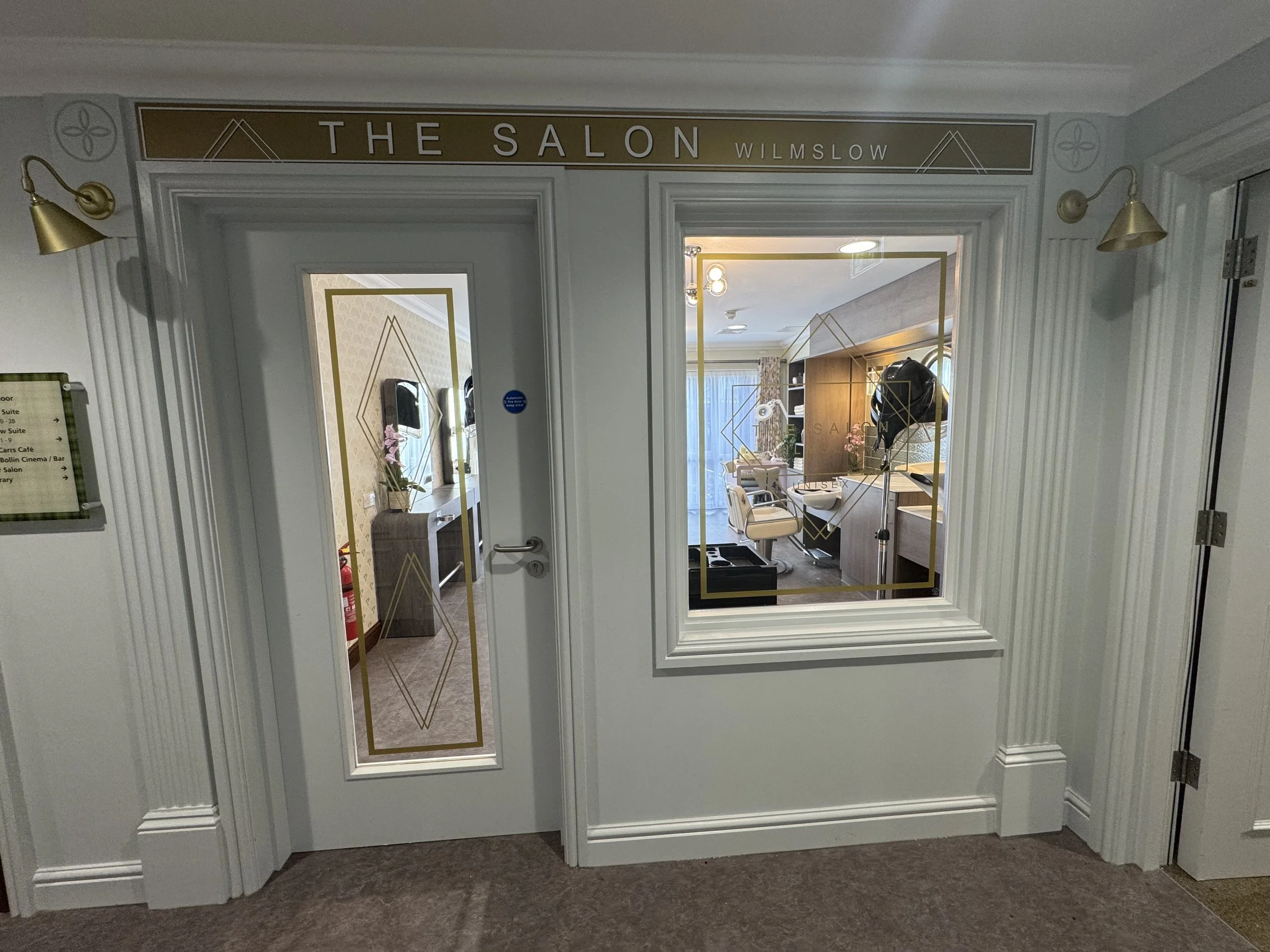 Entrance to a hair salon named The Salon Wilmslow with a door and a window showing the salon interior with chairs and salon equipment.