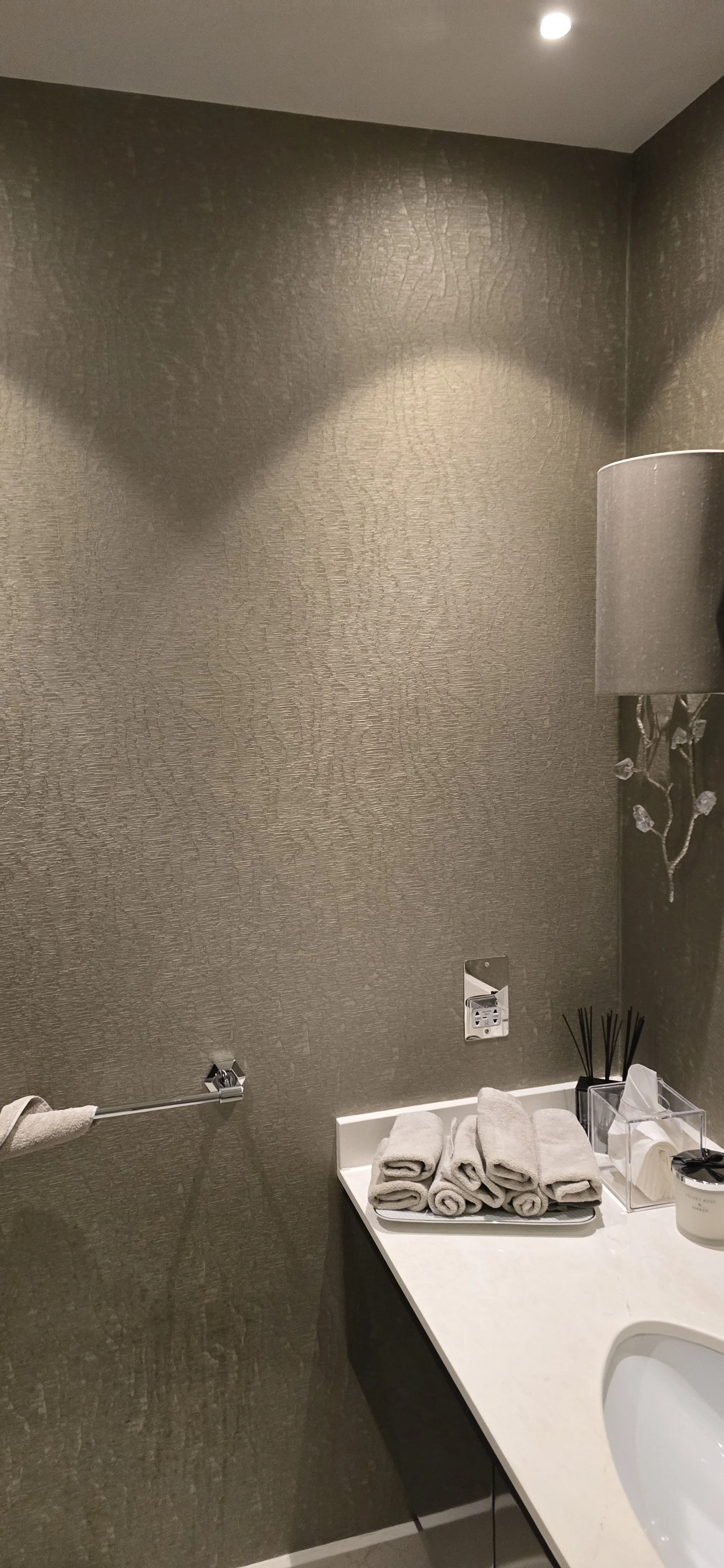 Luxury powder room decoration using Tektura textured vinyl wallcovering. High-quality finish around fixtures and lighting.