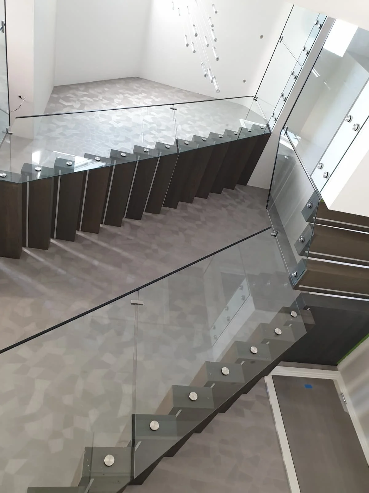 Complex staircase wallpaper installation. Precision pattern matching of geometric wallcovering in a modern luxury home.