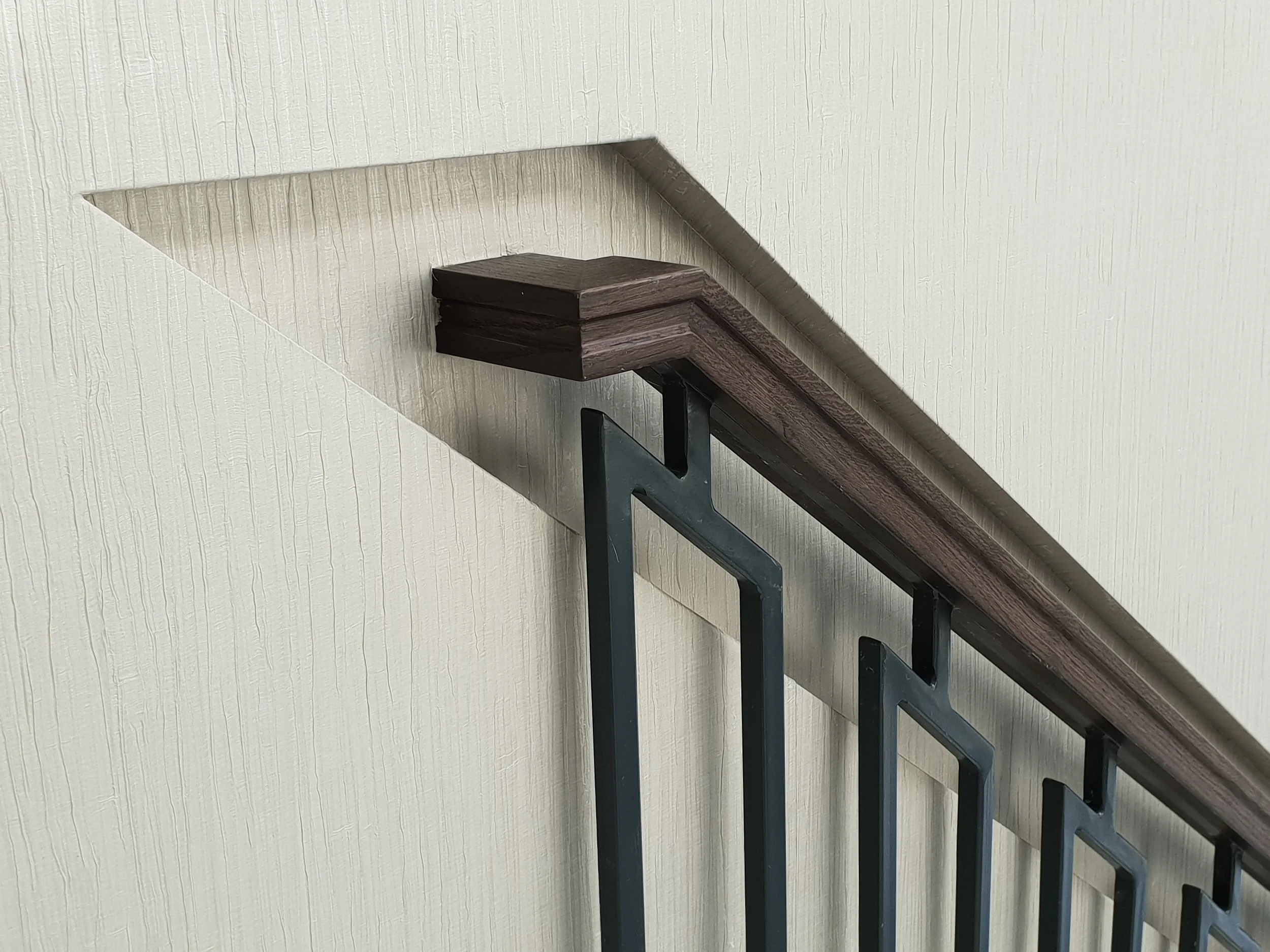 Expert wallpapering behind modern architectural fixtures and high-traffic staircase areas.