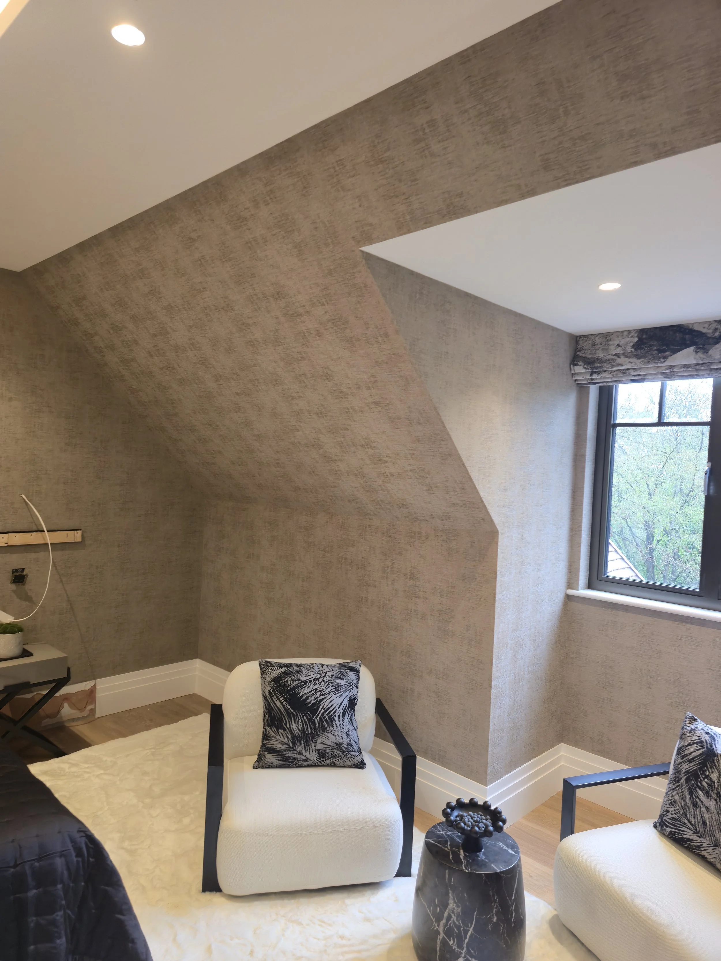 Navigating challenging architectural geometry, including sloped ceilings and window reveals, with Casamance luxury wallcoverings for a pristine, unified look.