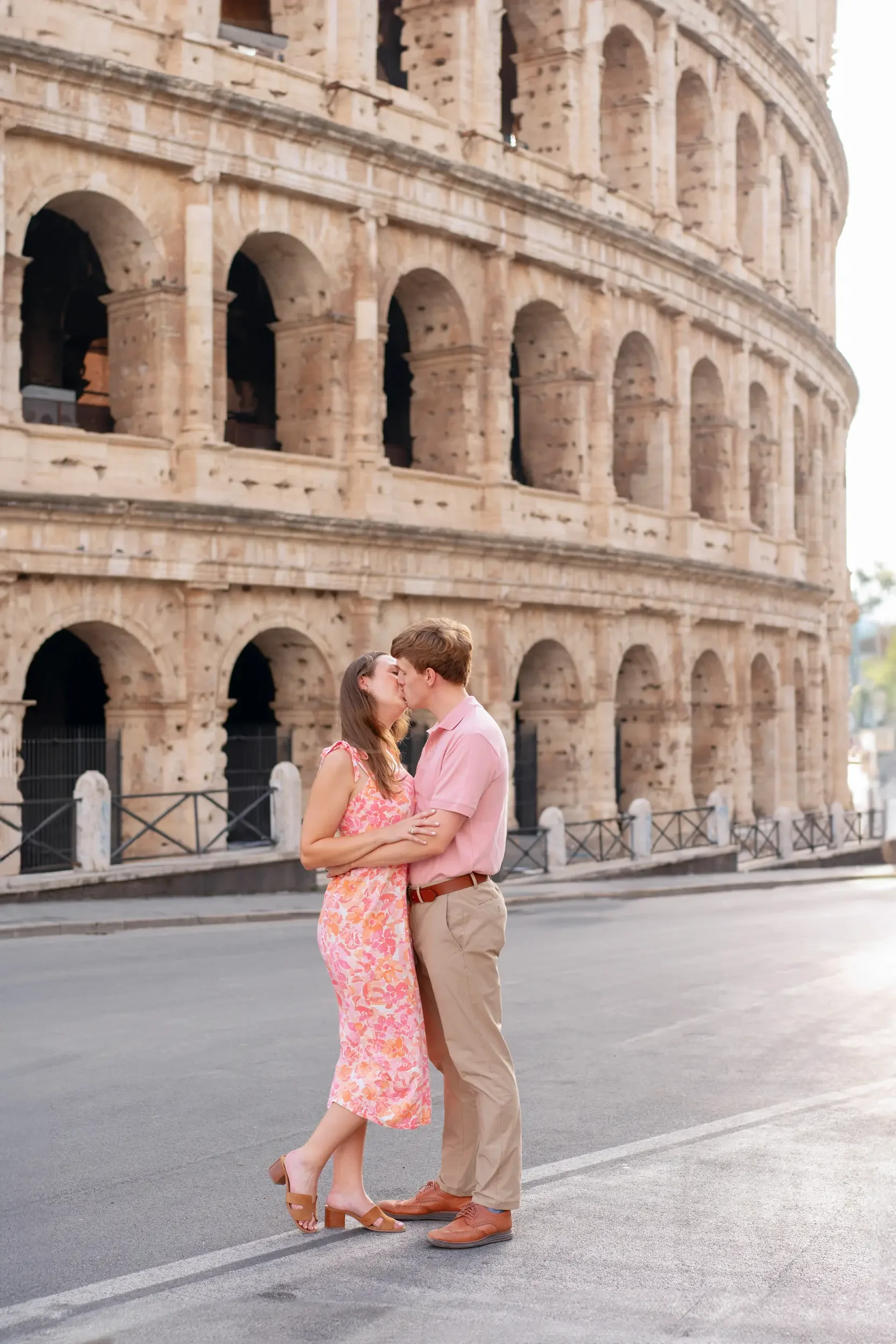 A couple kissing in front of the Colosseum in Rome, Italy.