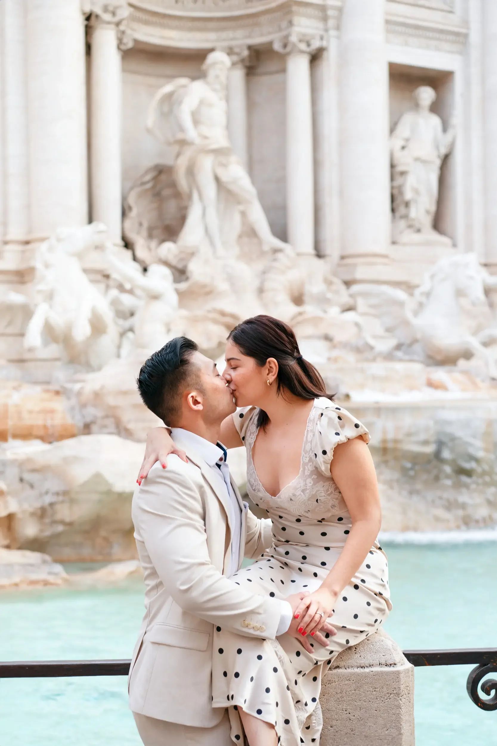 A couple kissing in front of the Trevi Fountain in Rome, Italy.
