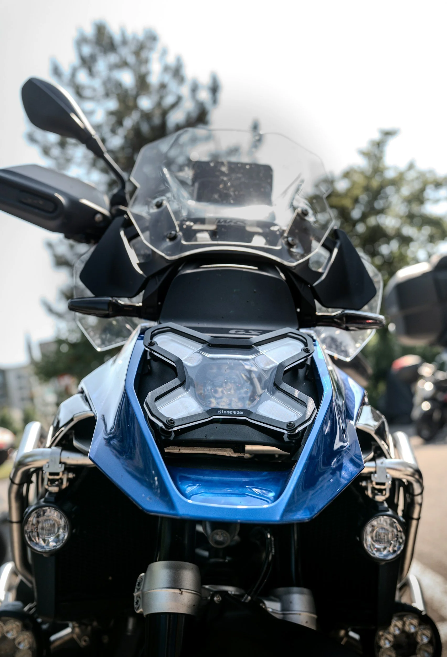 Vorderansicht eines blauen Motorrad mit Schutzverkleidung, Windschutzscheibe und Scheinwerfern, im Freien bei Tageslicht