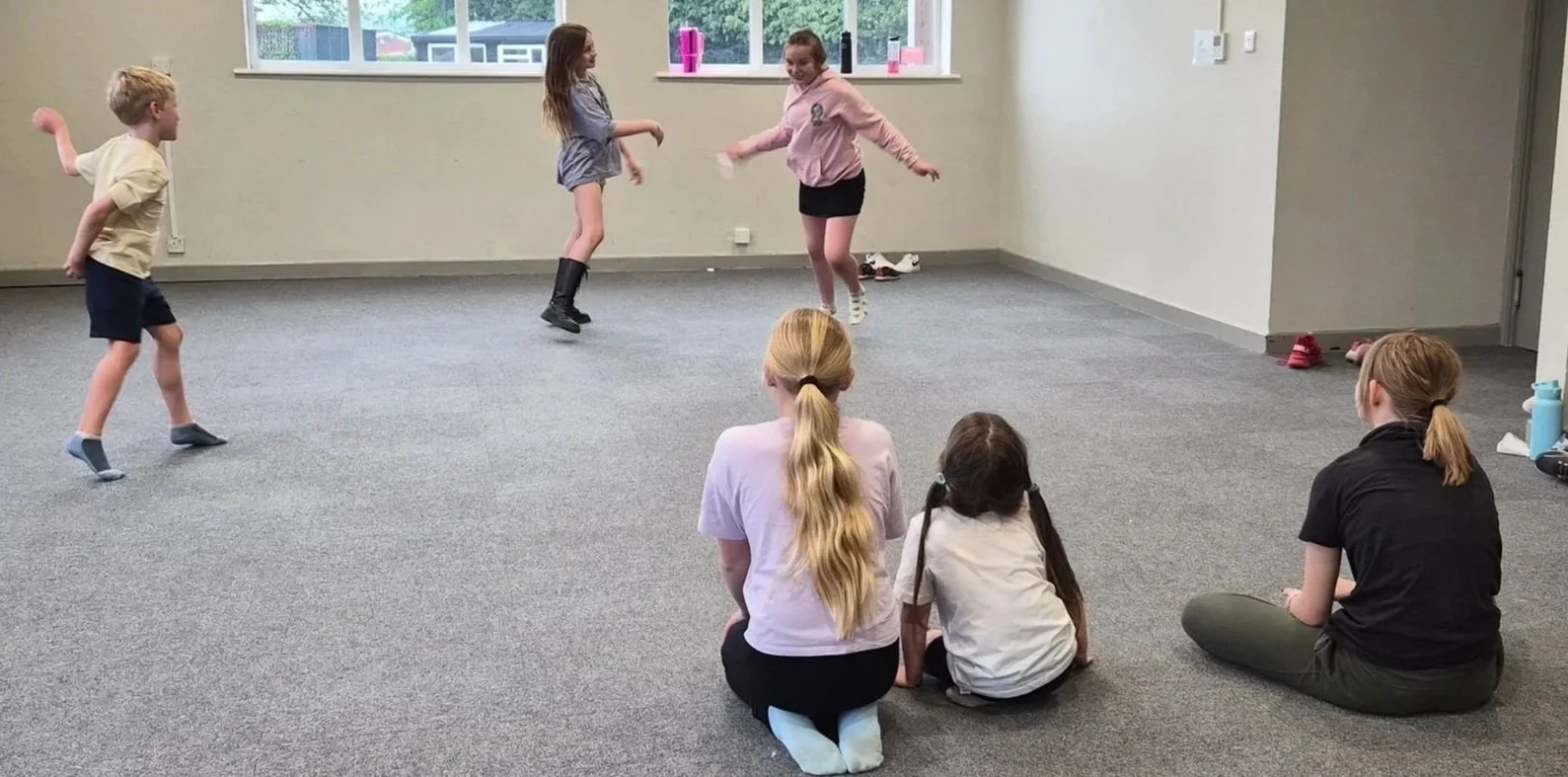 Children performing a drama activity while classmates watch at a weekly kids drama class in Farndon, near Chester