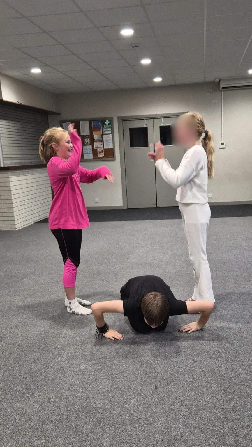 Children creating a group shape together during a drama game at a children's drama class in Farndon