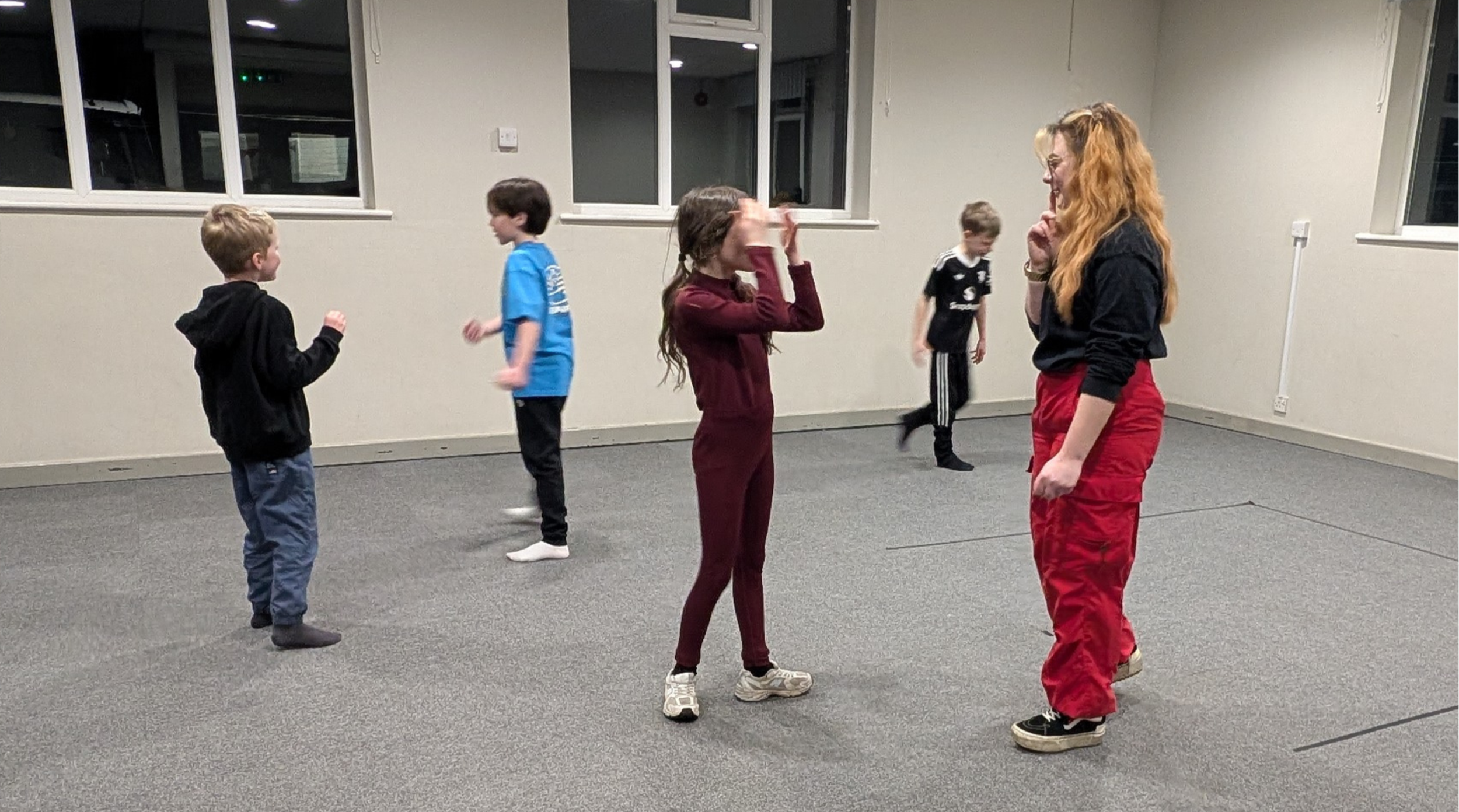 Children playing a drama warm-up game with founder Francesca Carr at a kids drama class in Farndon, near Chester