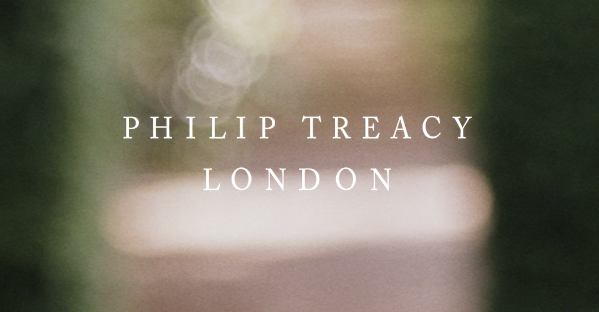 Texto en la pantalla que dice 'Philip Treacy London' en un fondo borroso y con tonos verdes y beige.