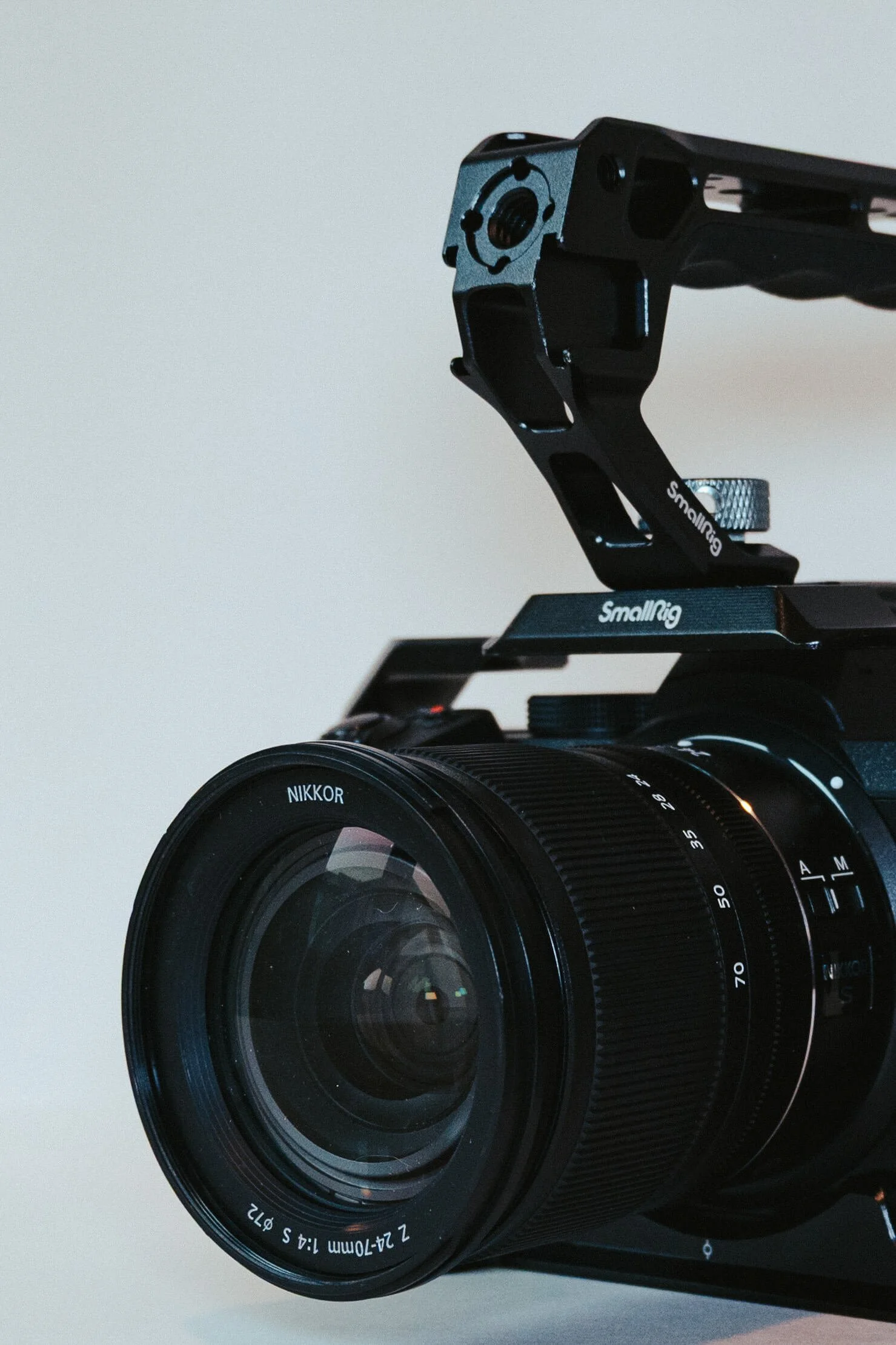 Close-up of a professional camera with a large lens, mounted on a stabilizer.