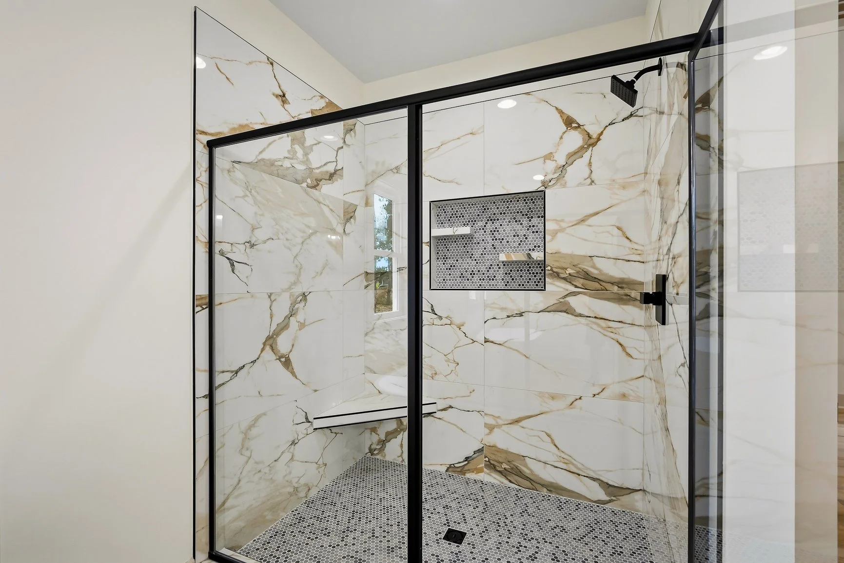 Primary bathroom oversized tile shower with inset
