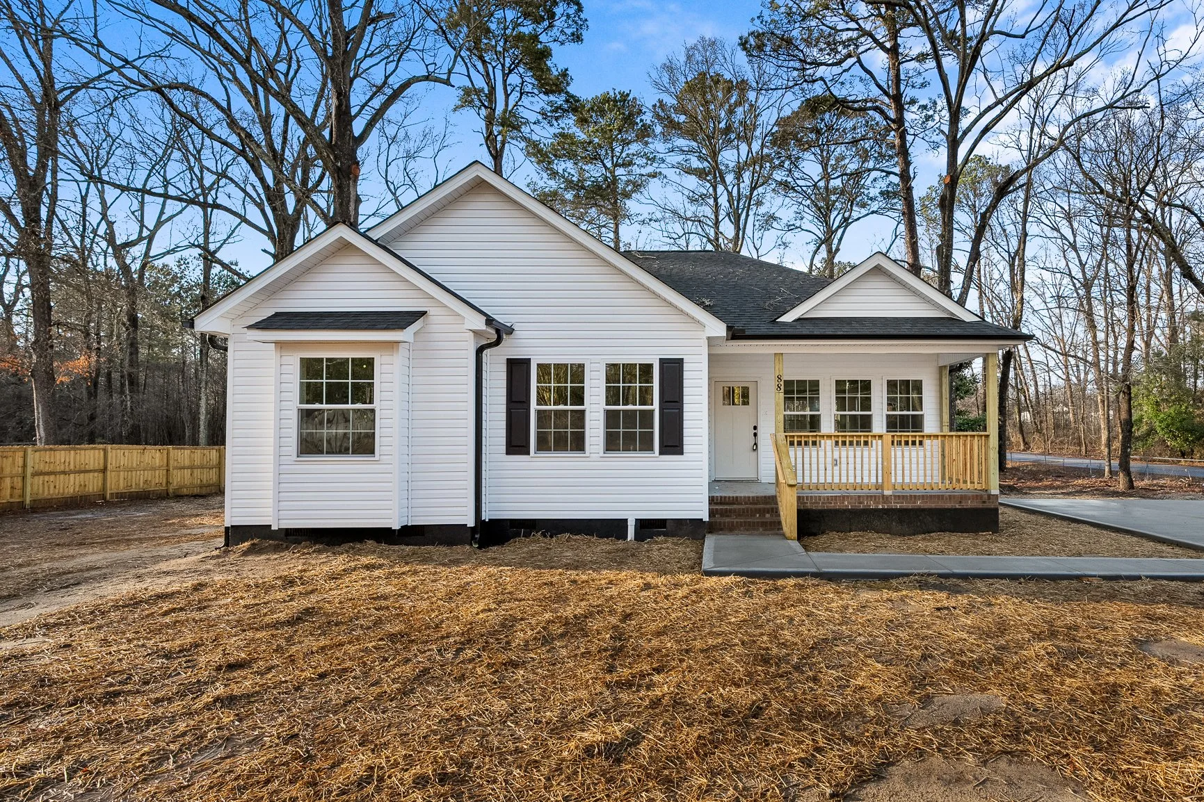 While vinyl sided farmhouse style house with front porch