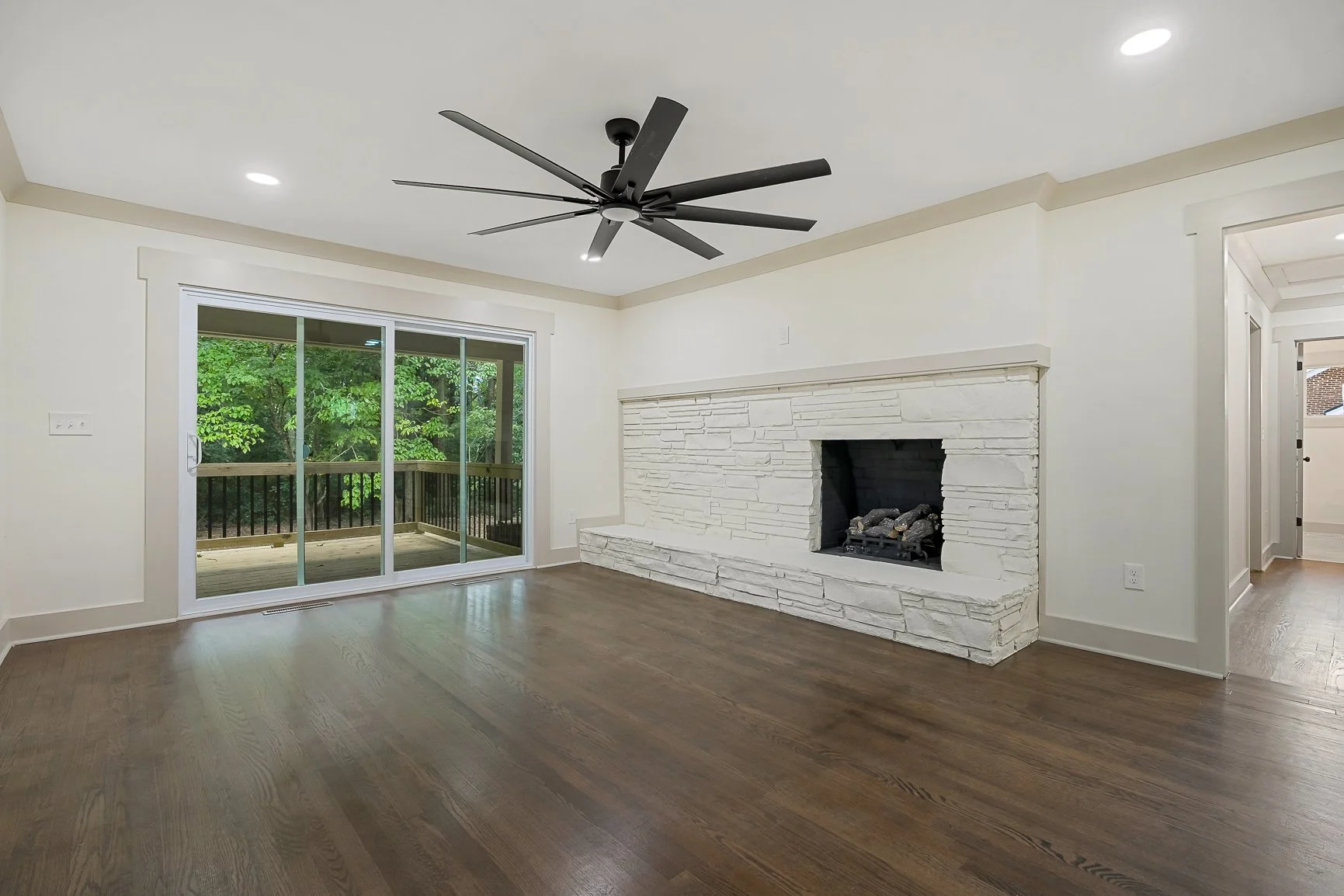 Living room at 227 Belton Dr with refinished hardwood floors, gas log fireplace, and access to rear deck