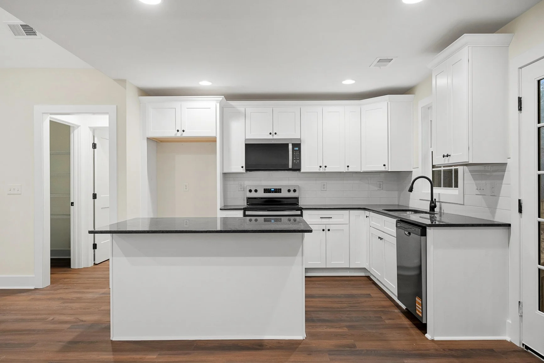 white kitchen black granite countertops stainless steel appliances kitchen island black hardware